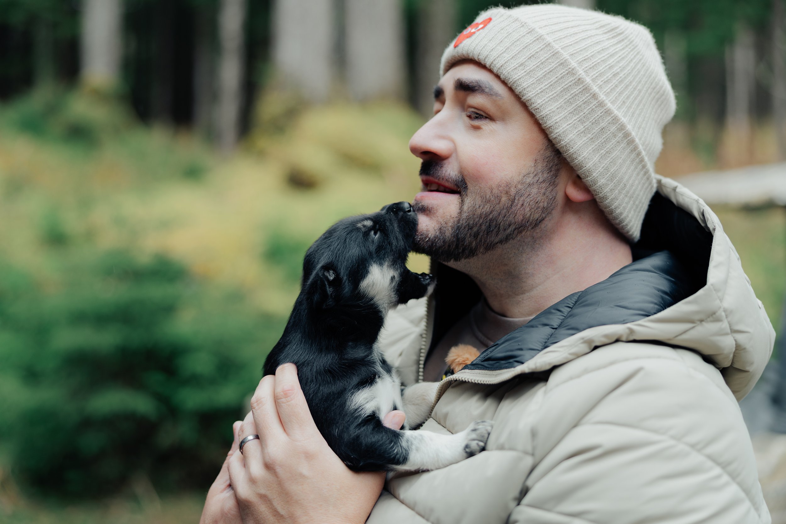 Ben and David holding 3-week-old husky puppies Sailor and Socks at Musher's Camp