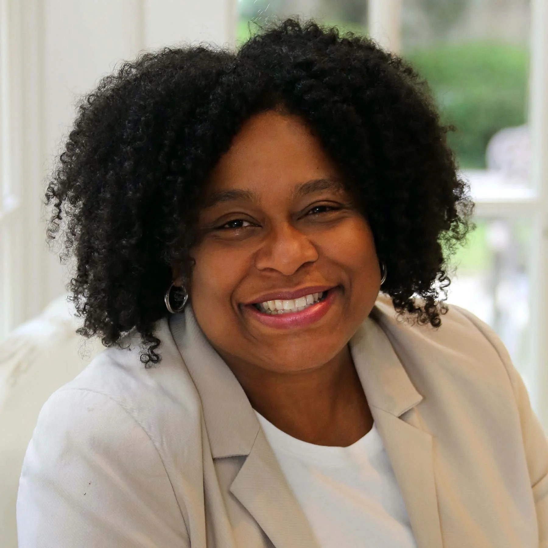 Dr. Vanessa Hawkins wearing a white blazer, sitting in front of a window.