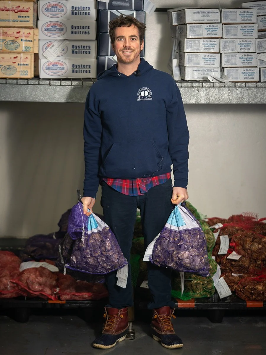 Chef Ian Maschal holding bags of shellfish.