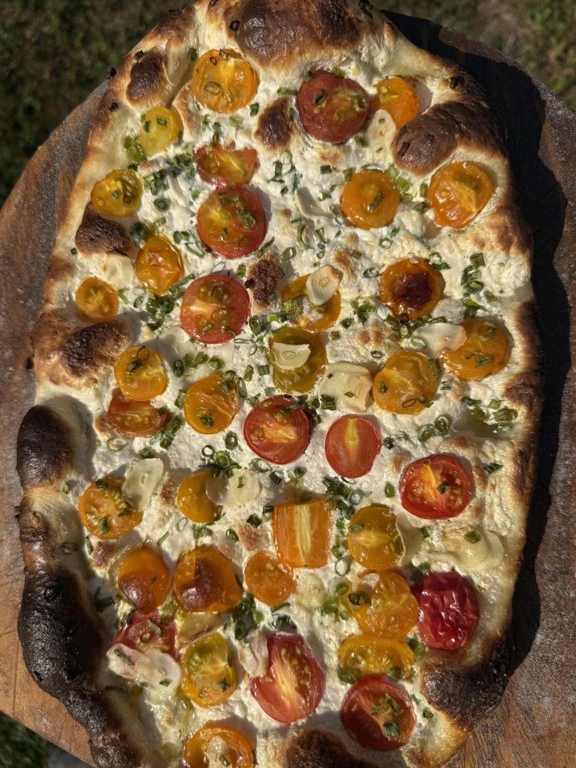 Super Dough pizza topped with colorful tomatoes and herbs.