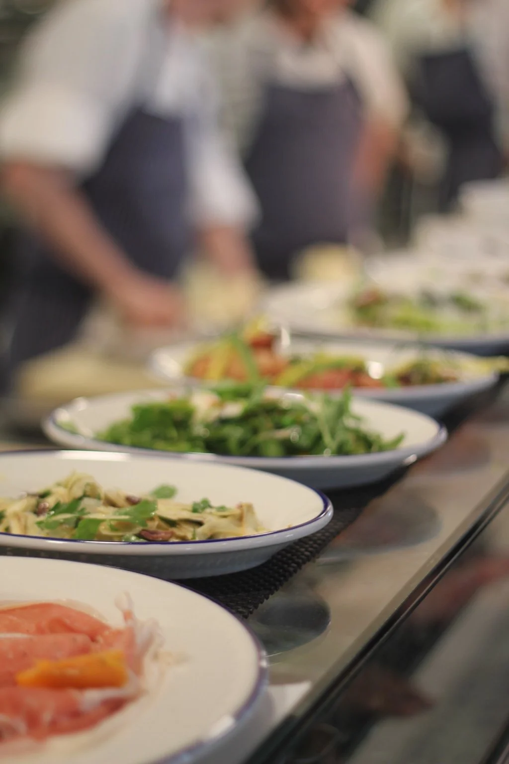 Plated dishes lined up for service in the kitchen.