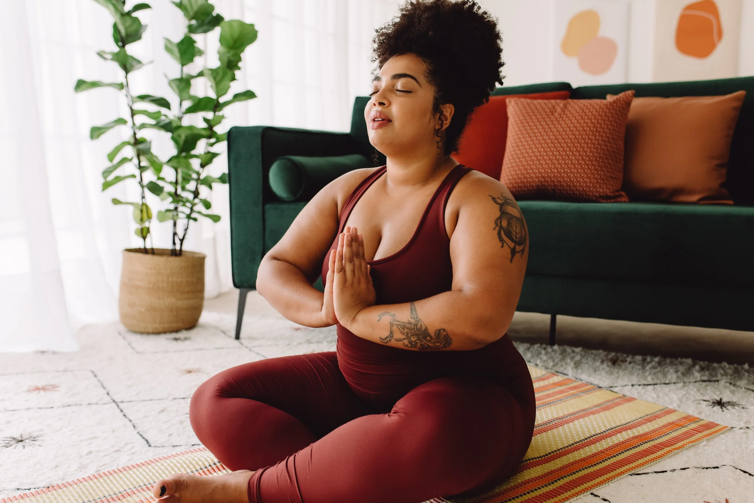 Woman meditating on the floor with their hands in the prayer position