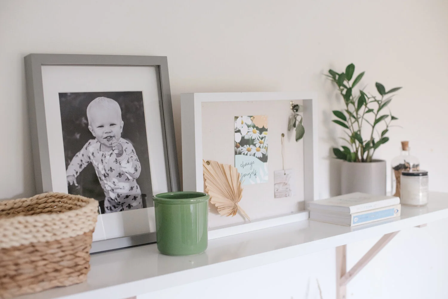 Close up of framed images and art on the shelf.