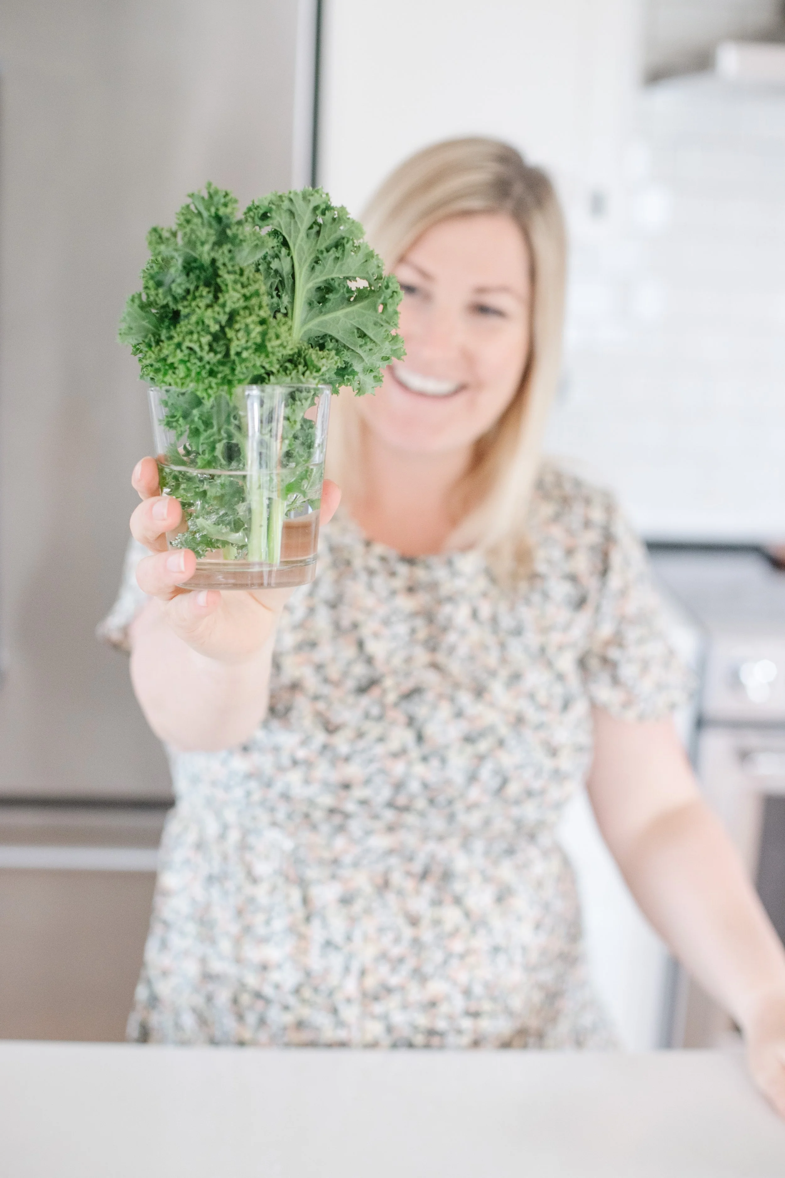 Tasha from The Purposeful You holding up kale stored in a glass with water