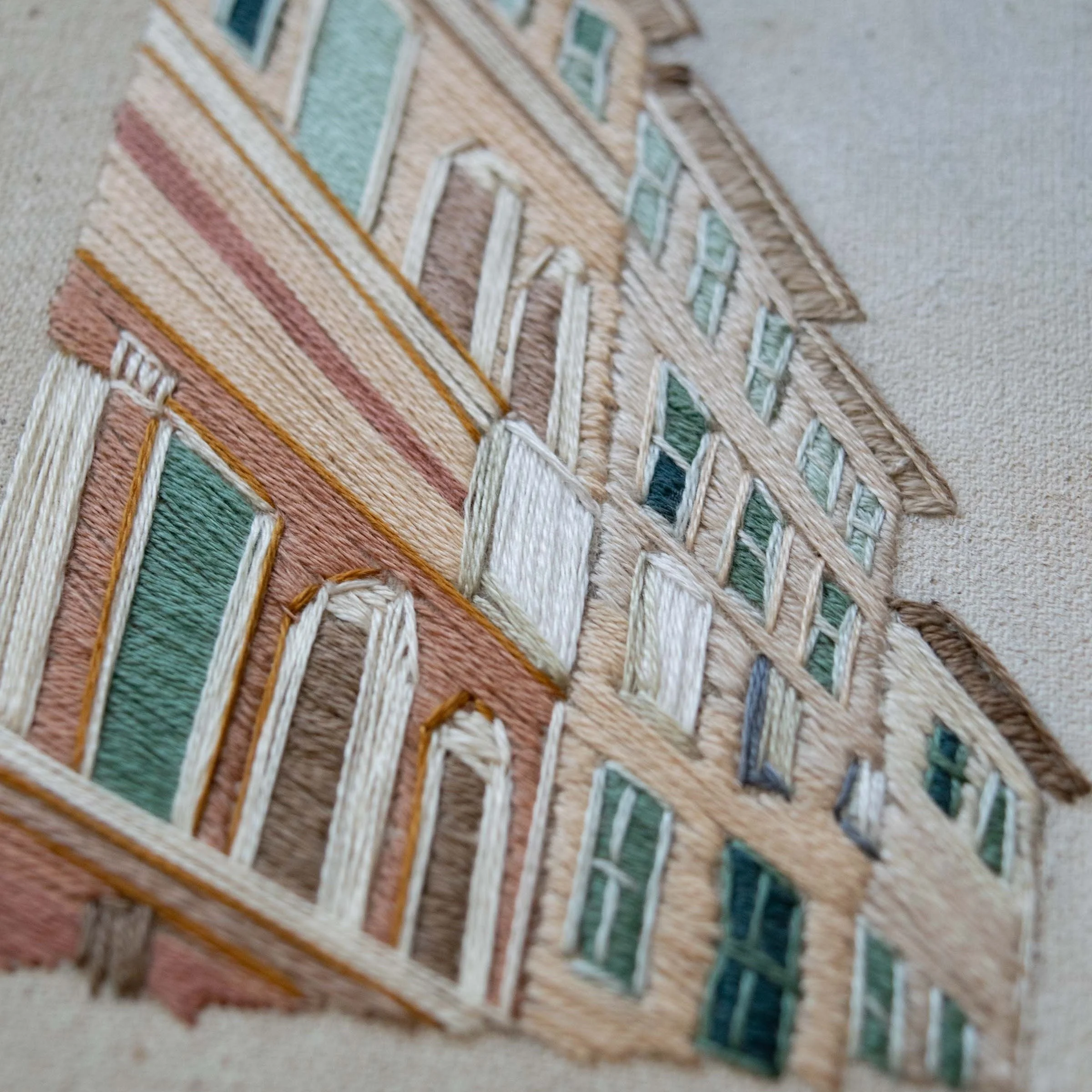 Closeup image of original mixed media embroidery of architecture.