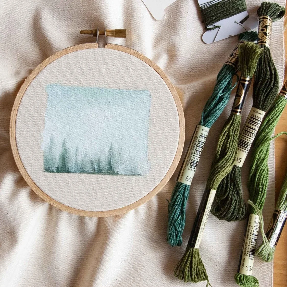 Mixed-media embroidery artwork featuring redwood trees created with paint and thread. This nature-inspired textile art combines hand embroidery and painted details to capture the texture, depth, and beauty of towering redwood forests.