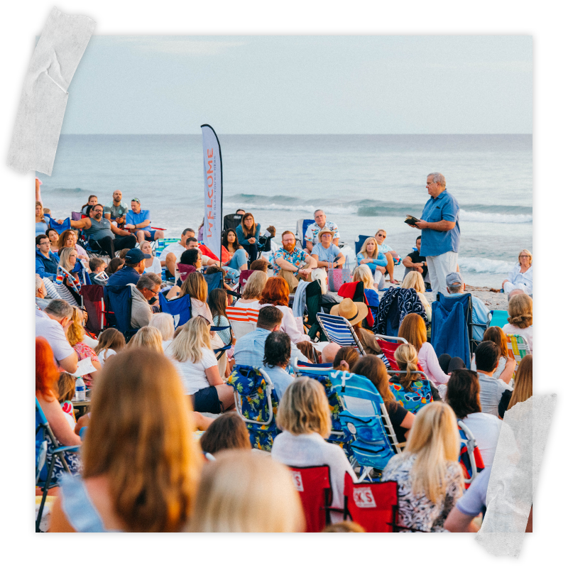 A large group of families gather for a sunrise worship service on the beach at Easter