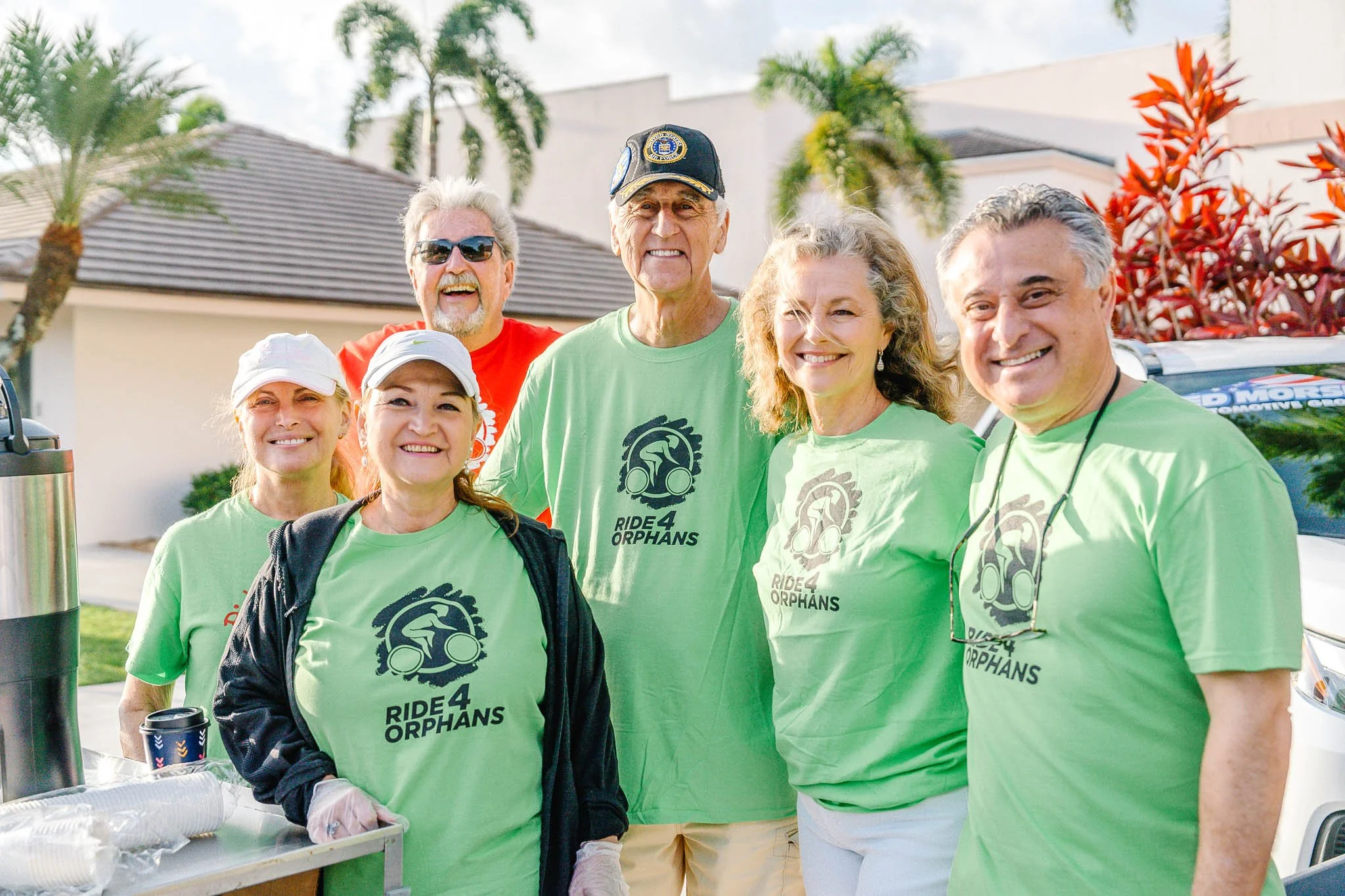 A man with glasses, a bald head, and a goatee speaking at a podium, wearing a dark blazer and white shirt, making a point with his hand, with a large book on the podium.