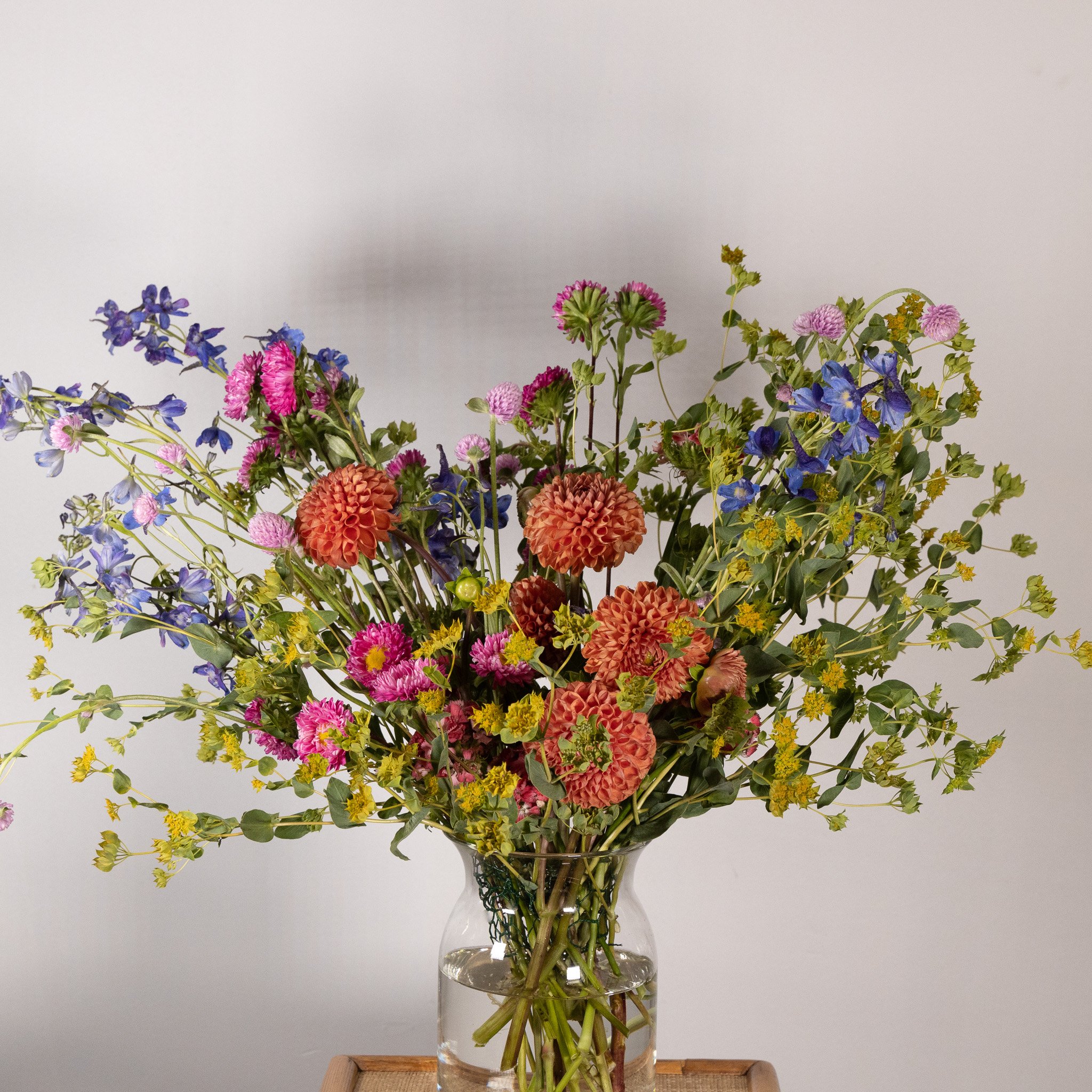 Colorful bouquet of flowers in a glass vase on a wooden table