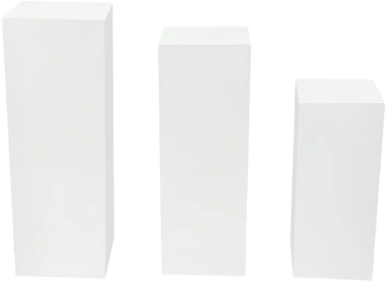 Three tall white rectangular display pedestals of varying heights against a white background.