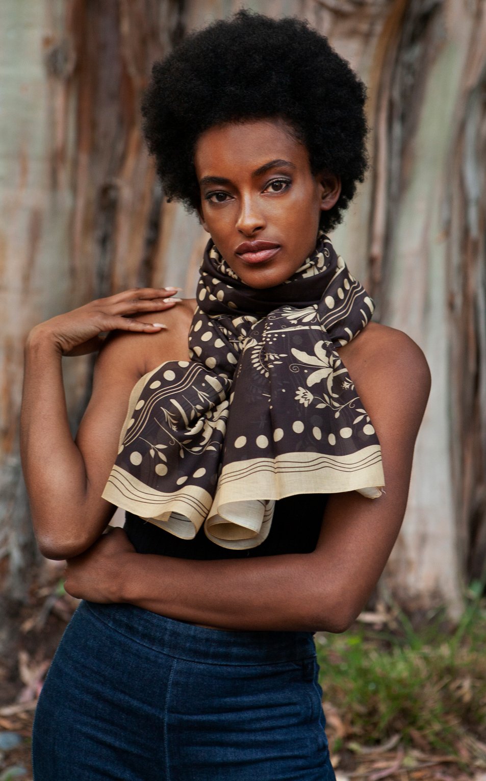 Woman wearing brown and cream palm tree printed tropical cotton scarf around neck