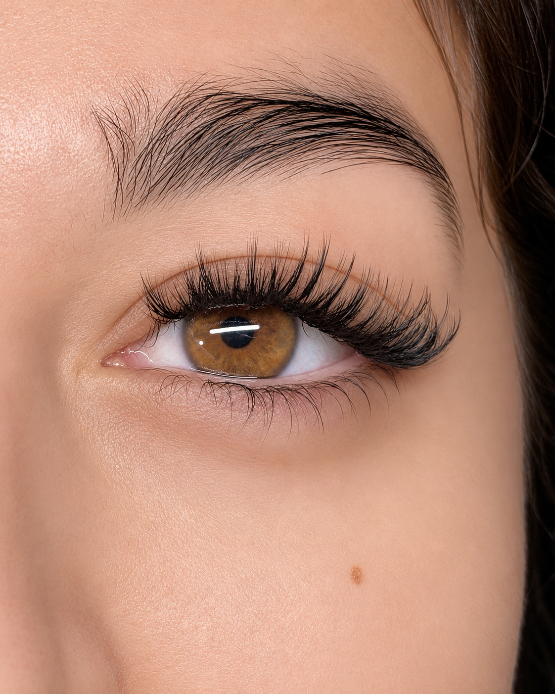 Open magazine showing a close-up photo of a woman's face with makeup, a cotton pad on her eye, and various beauty tools on the page.