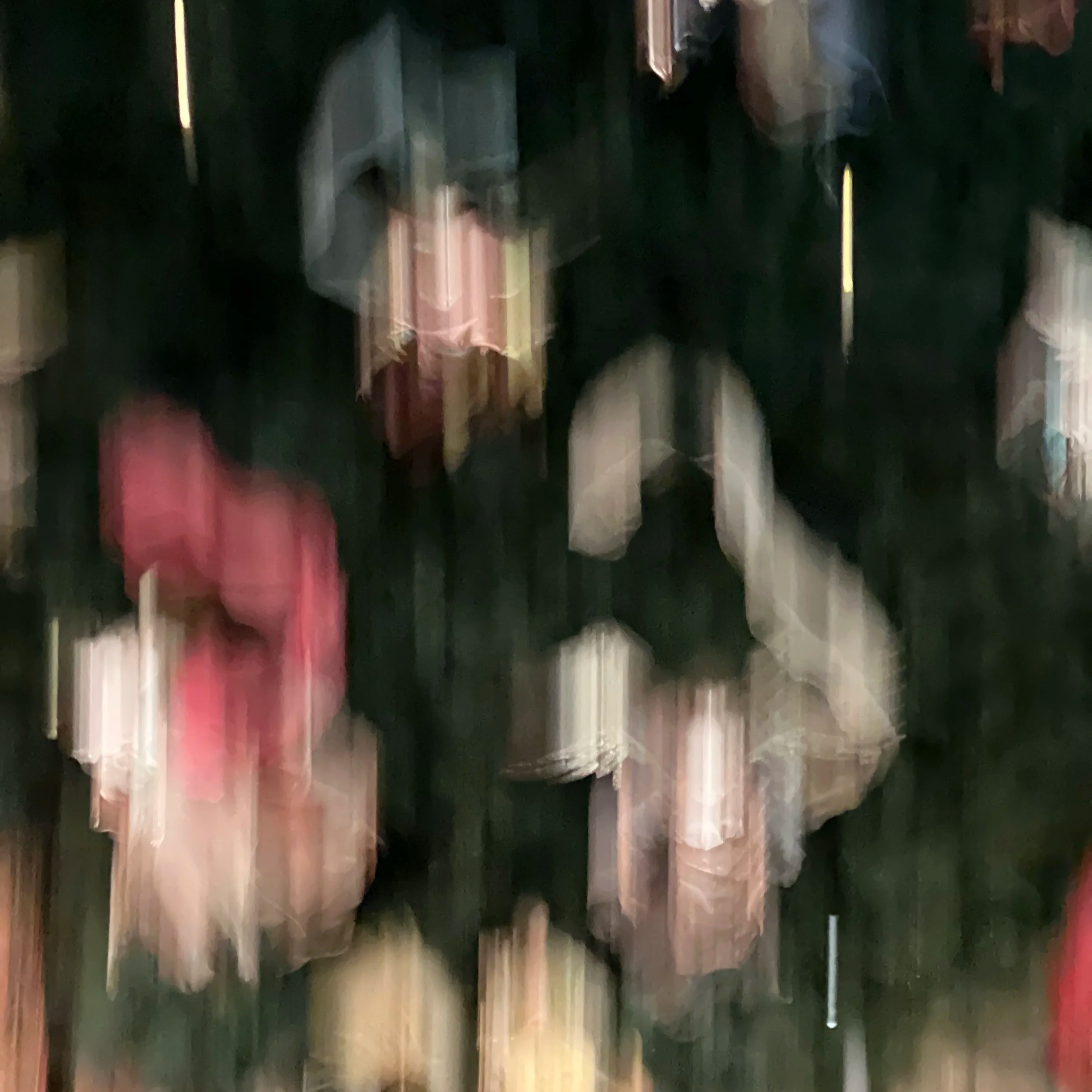 abstract blurry colors of pink, yellow, and gray against a black background