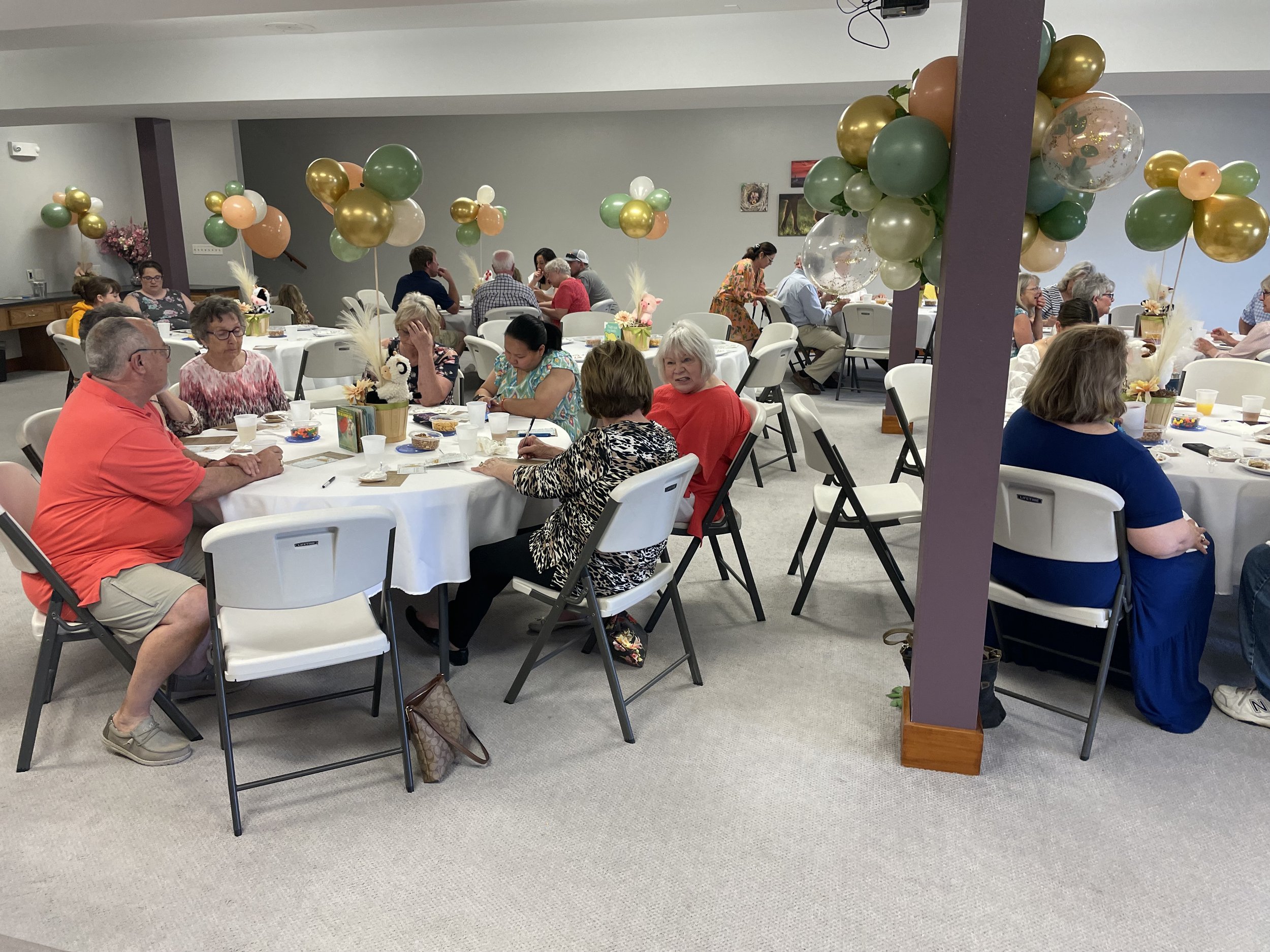 Guests at round tables with balloon decorations at Life's Finer Moments venue in Clay Center Kansas.