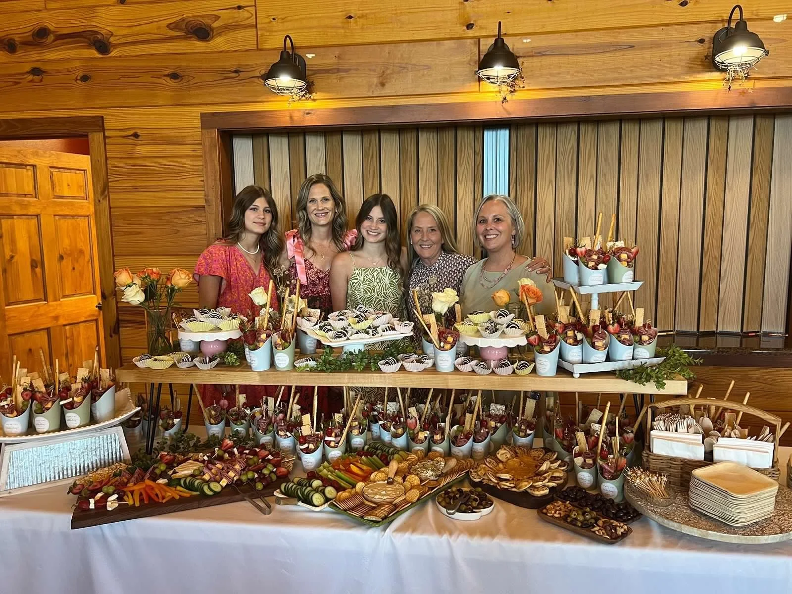 Women behind their two tiered table filled with charcuterie at Clay Center, KS venue.