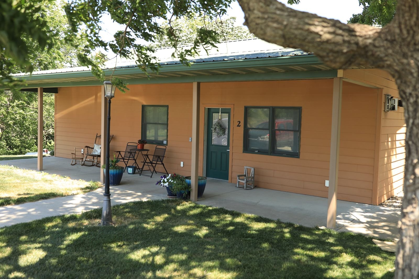 tan cabin with front porch is rented instead of a Clay Center hotel room