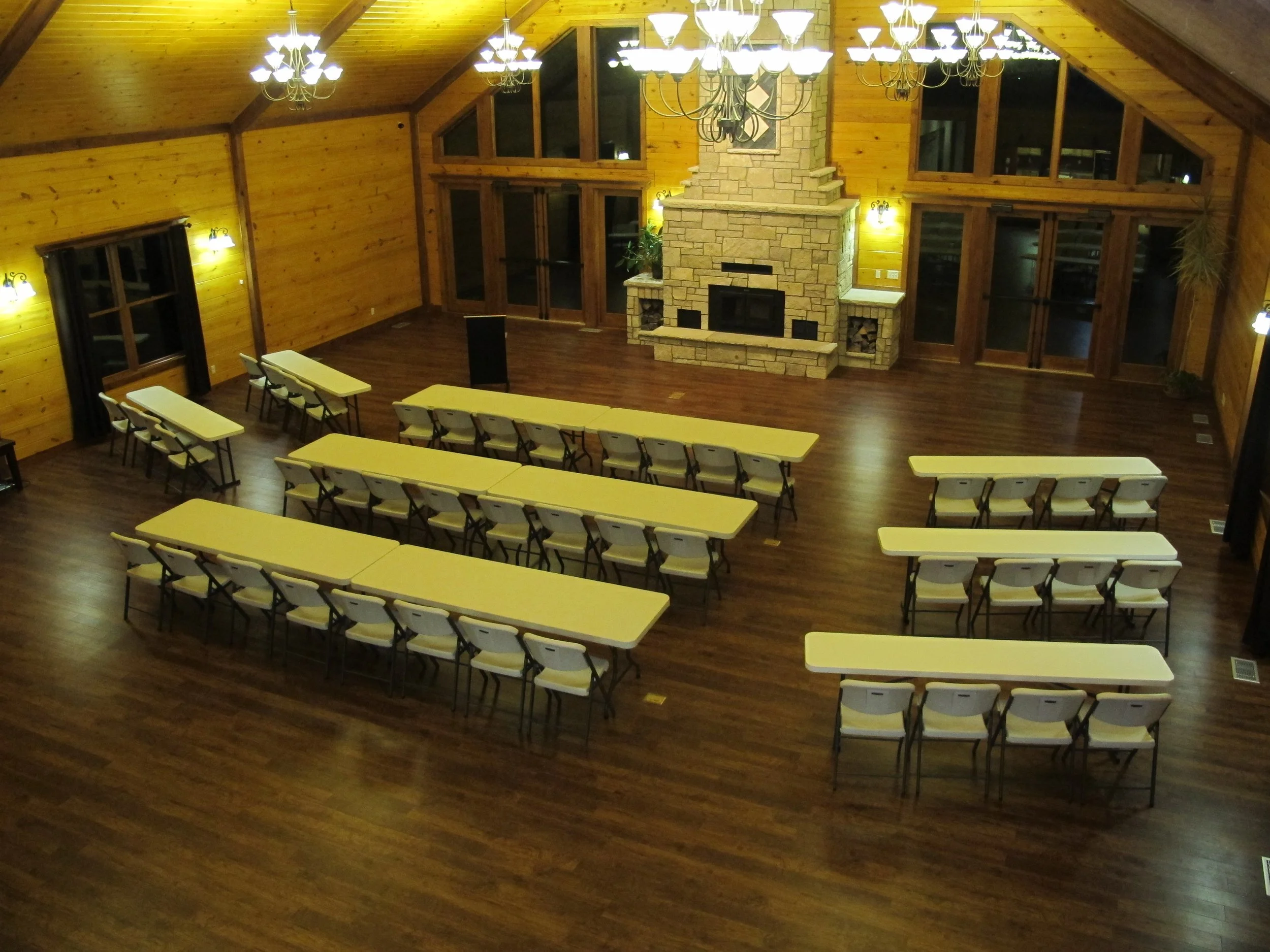 Large wood room set up with seminar tables and fireplace.