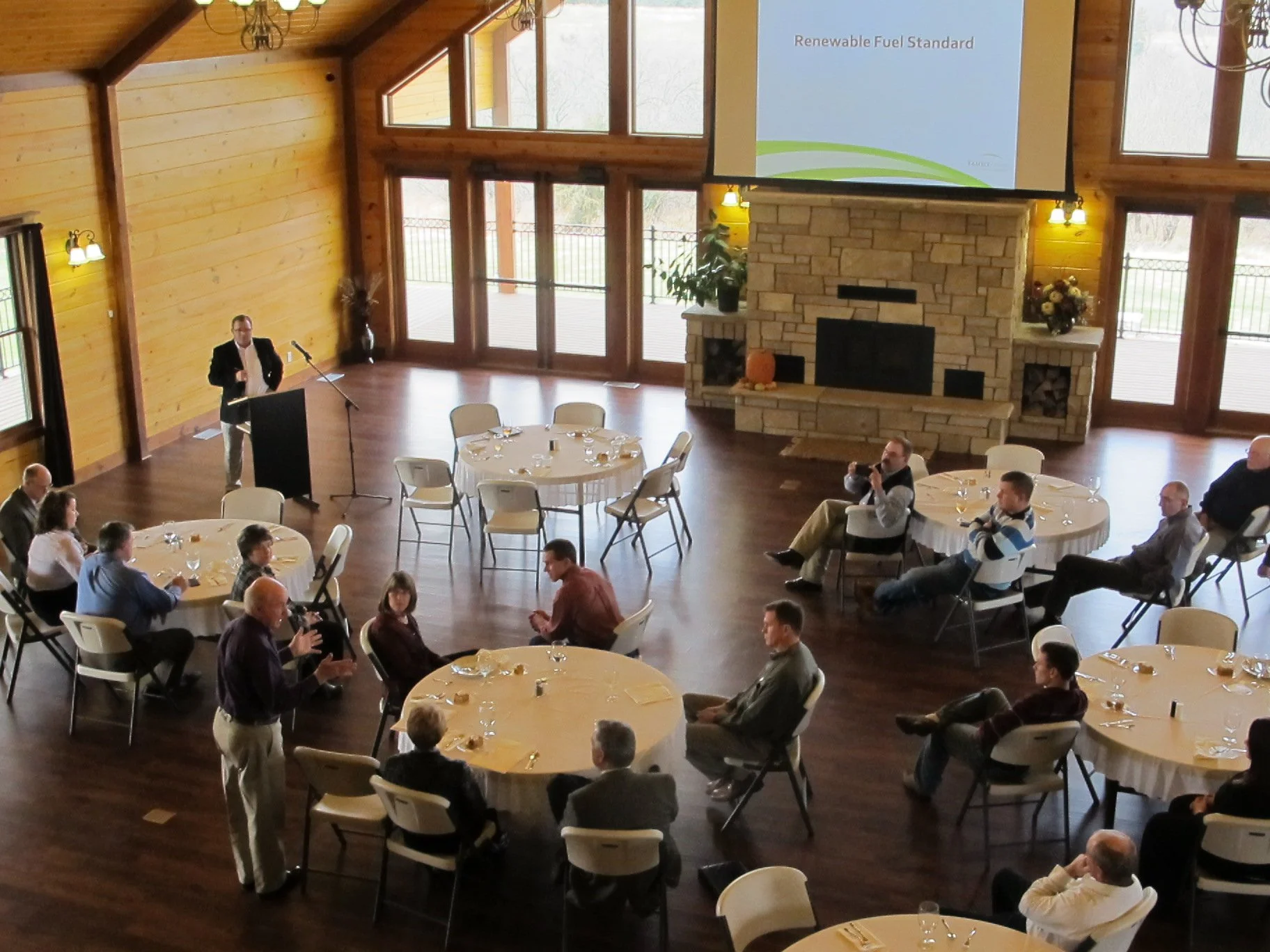 Guests at tables in venue at Clay Center, KS with speaker and PowerPoint