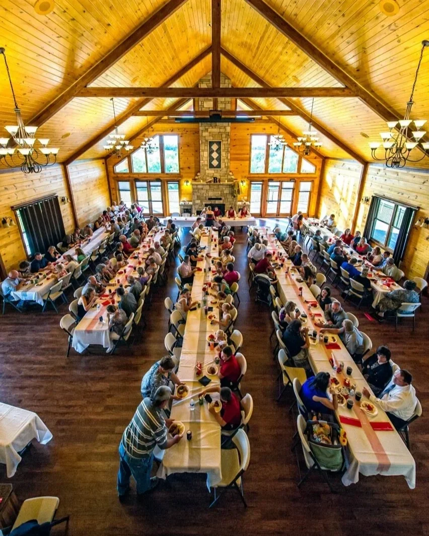Banquet in large room with vaulted wood ceiling and tall fireplace