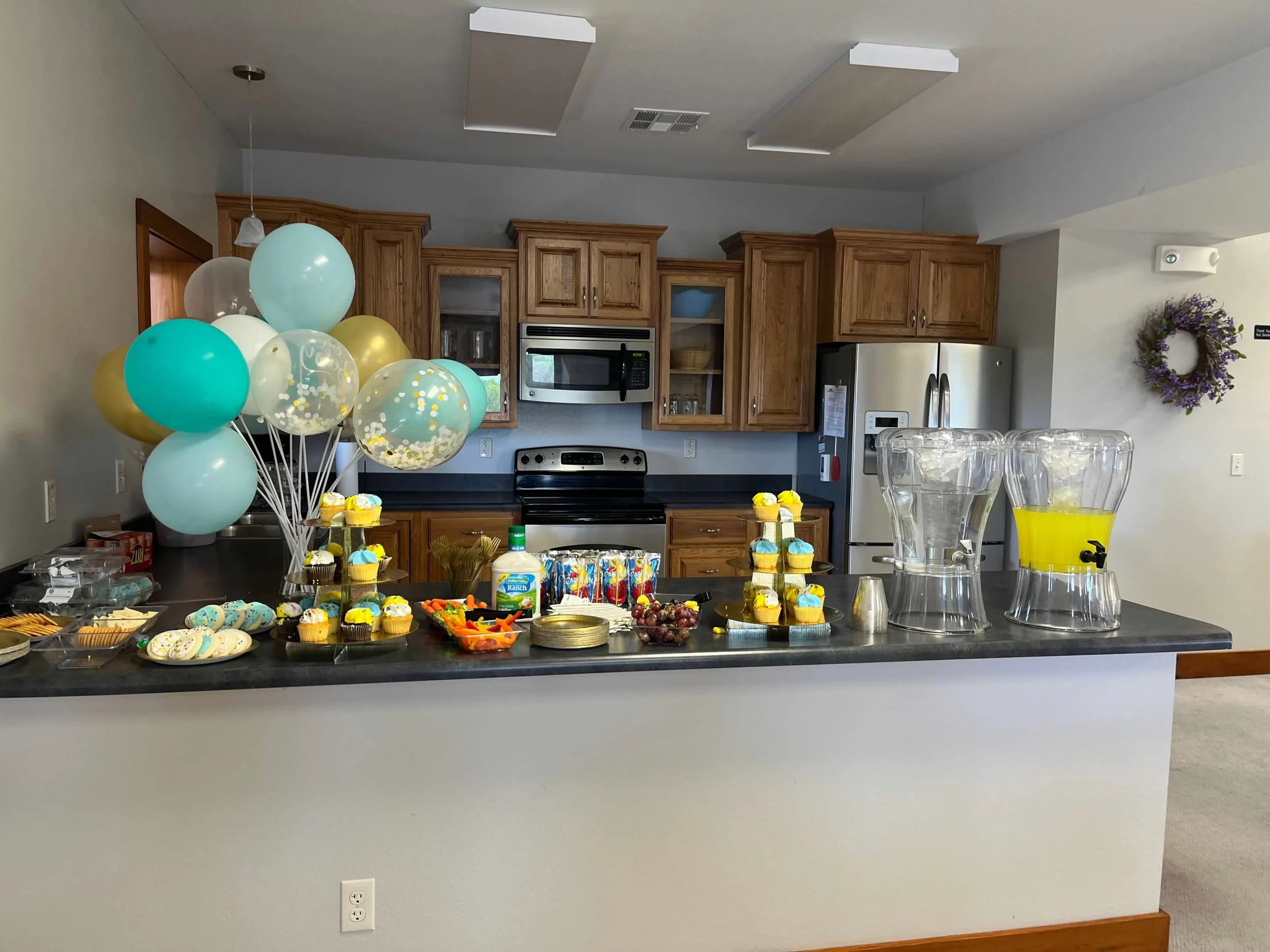Kitchen serving counter with snacks and balloons at Lower Level in Life's Finer Moments venue.