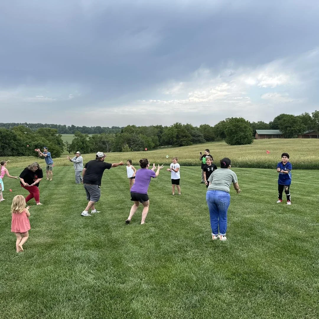 Egg toss between partners on lawn at KS outdoor venue