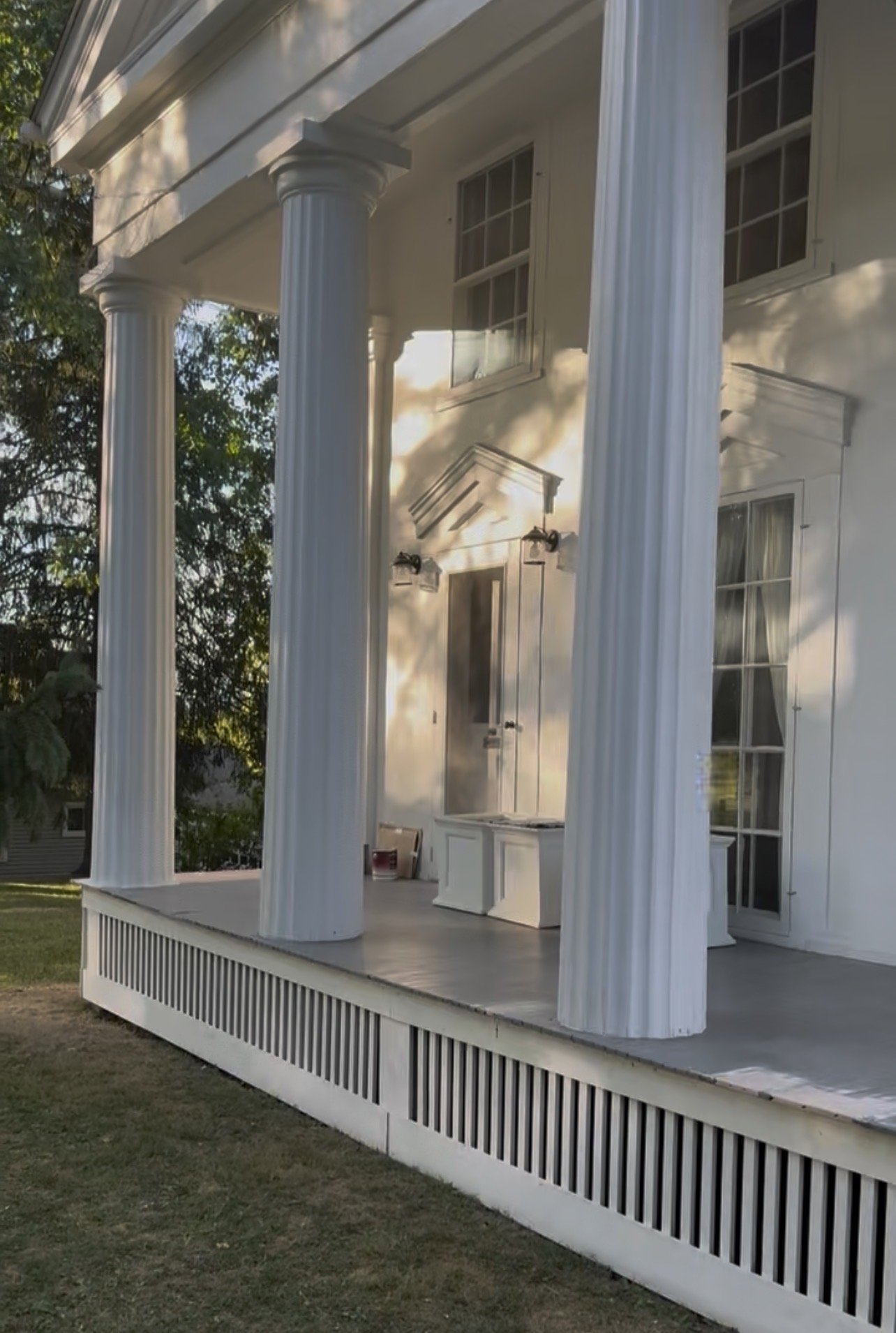 A front porch with restored grecian columns located in Hamilton, New York.