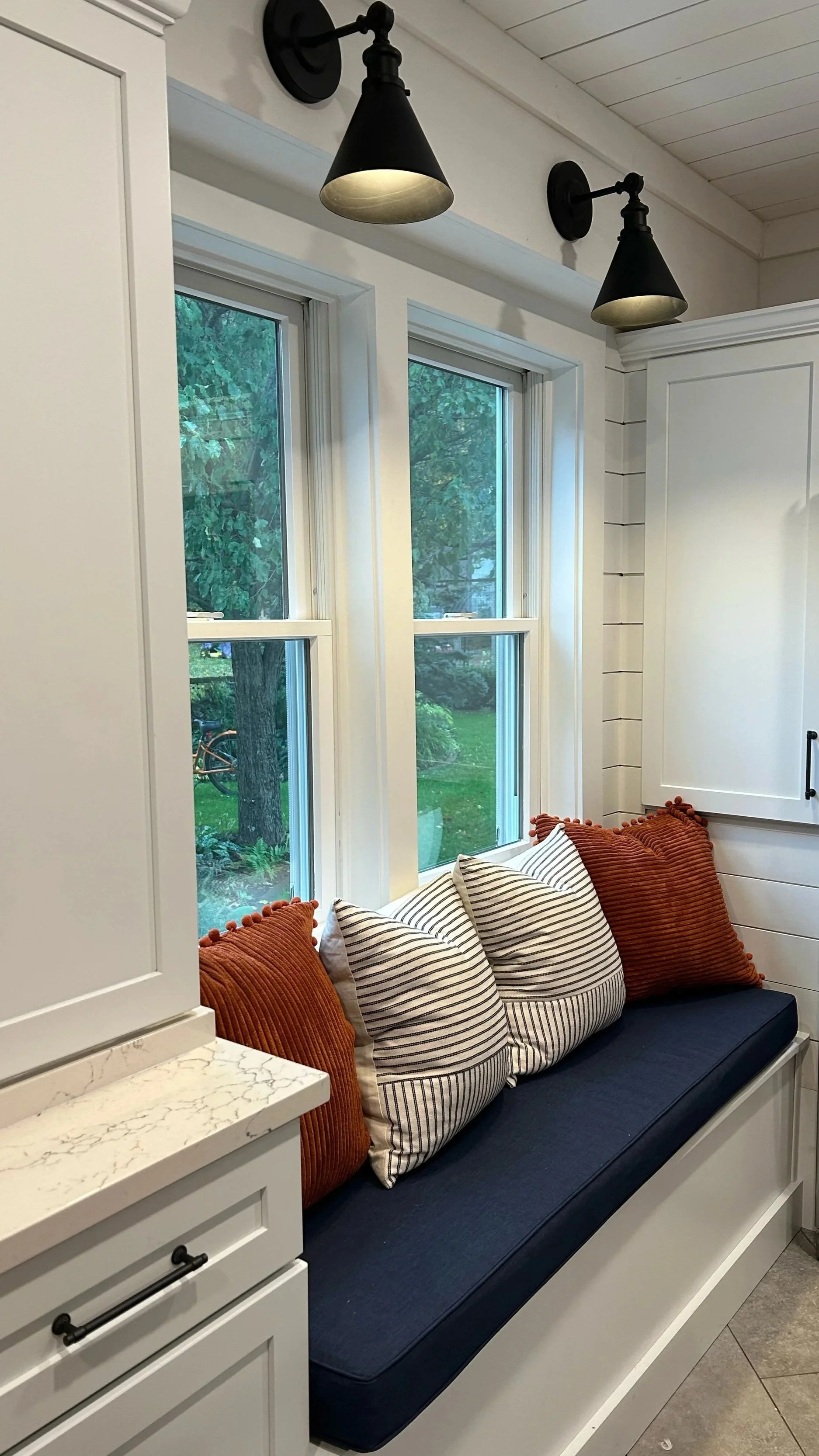 A bench seat in a newly renovated white kitchen in Central New York by a construction company located in Hamilton, NY.
