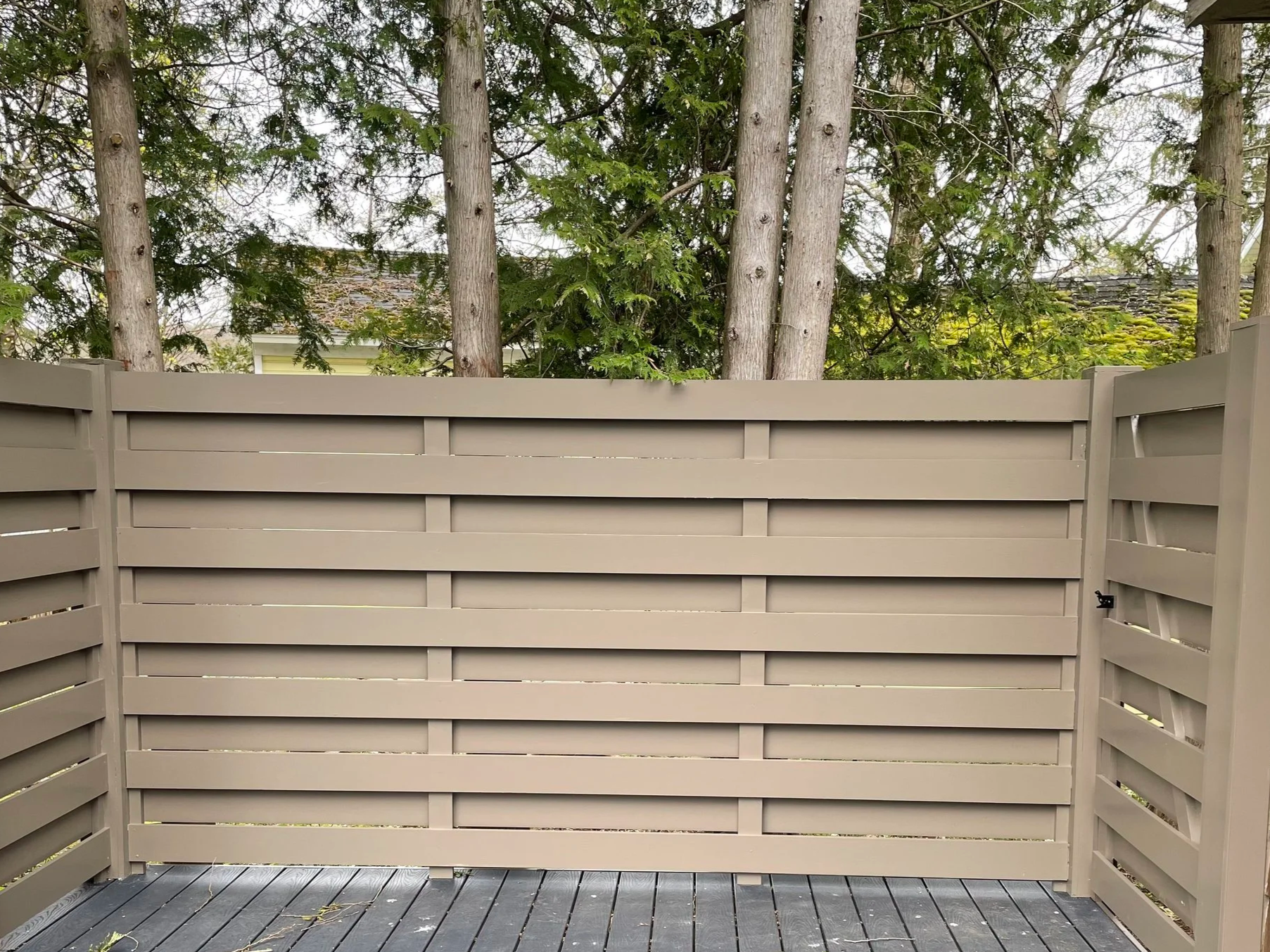 A new composite deck with a pvc privacy fence built by a construction company in Hamilton, NY.