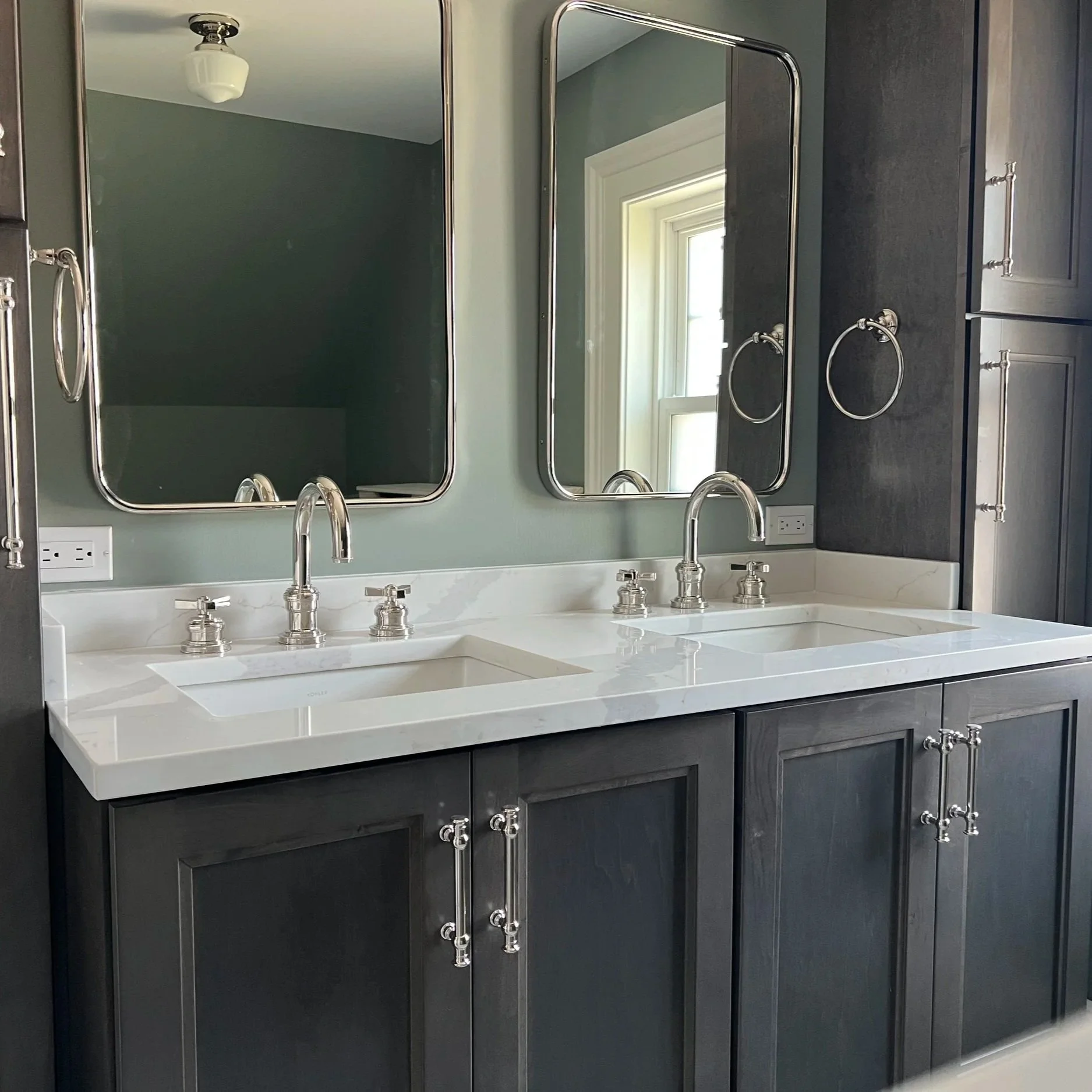 Bathroom remodel with a double vanity and polished nickel faucets completed by a general contractor in Hamilton, NY.