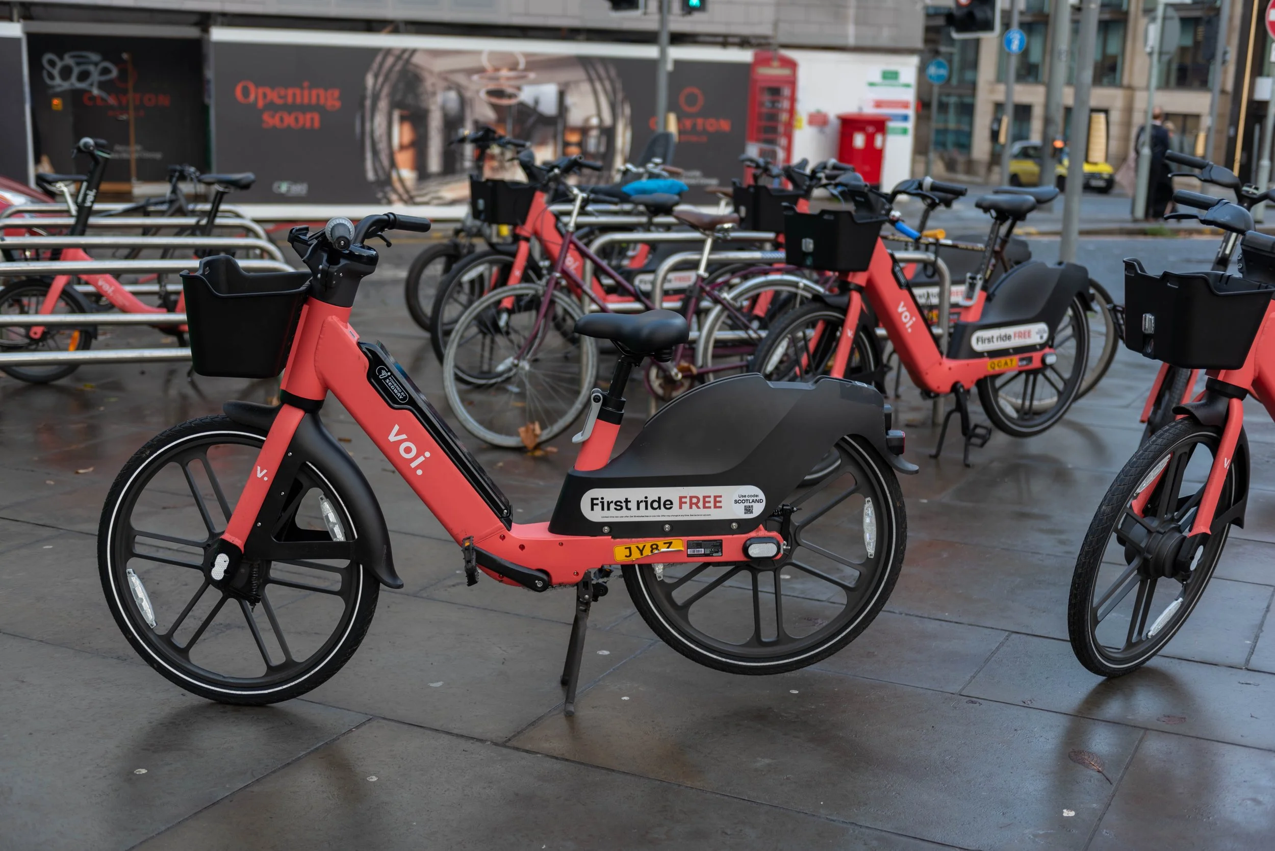 Several Voi e-bikes parked at a docking area in central Edinburgh