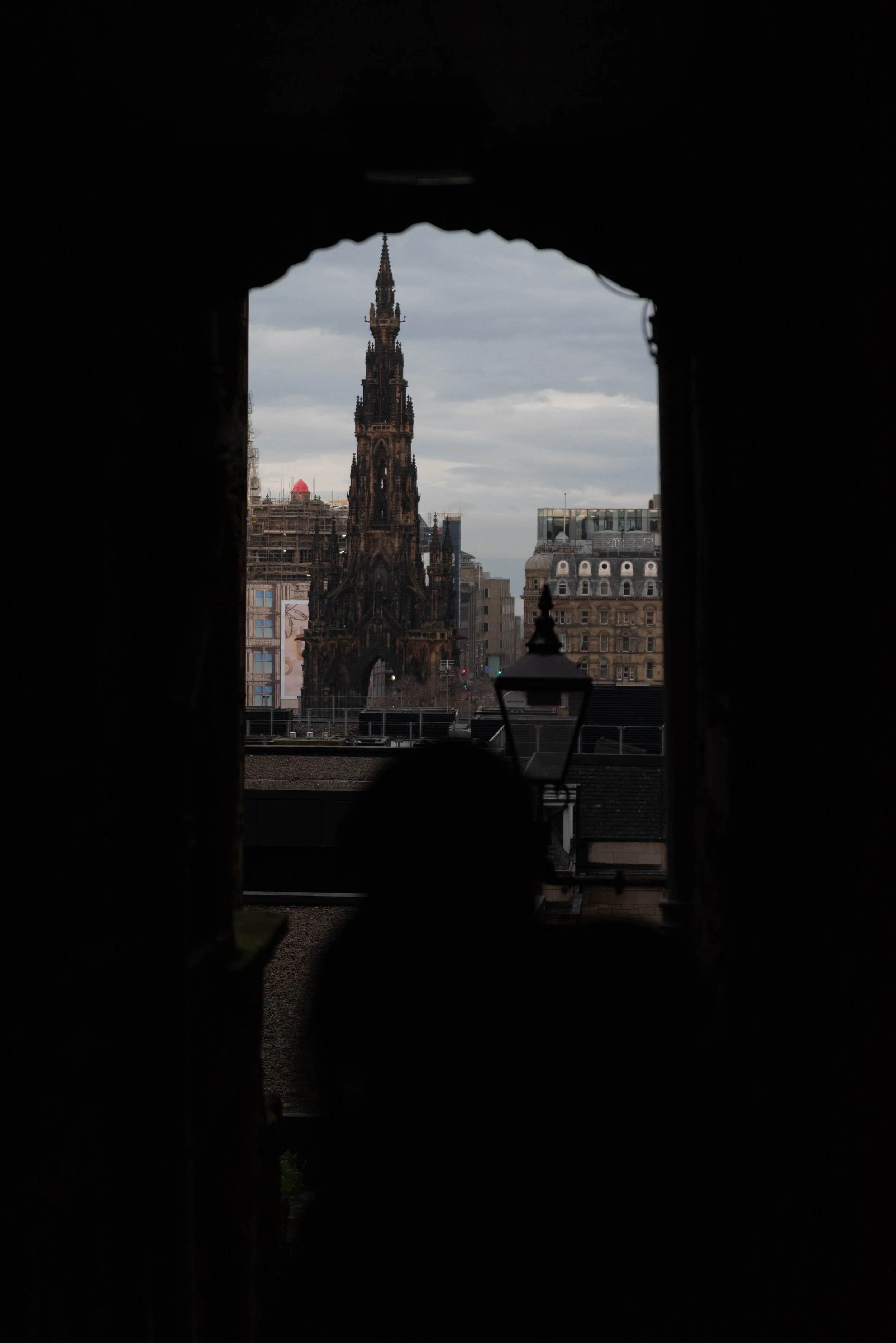 View along Advocate’s Close, a narrow Edinburgh alleyway, with a framed view of the Scott Monument in the distance
