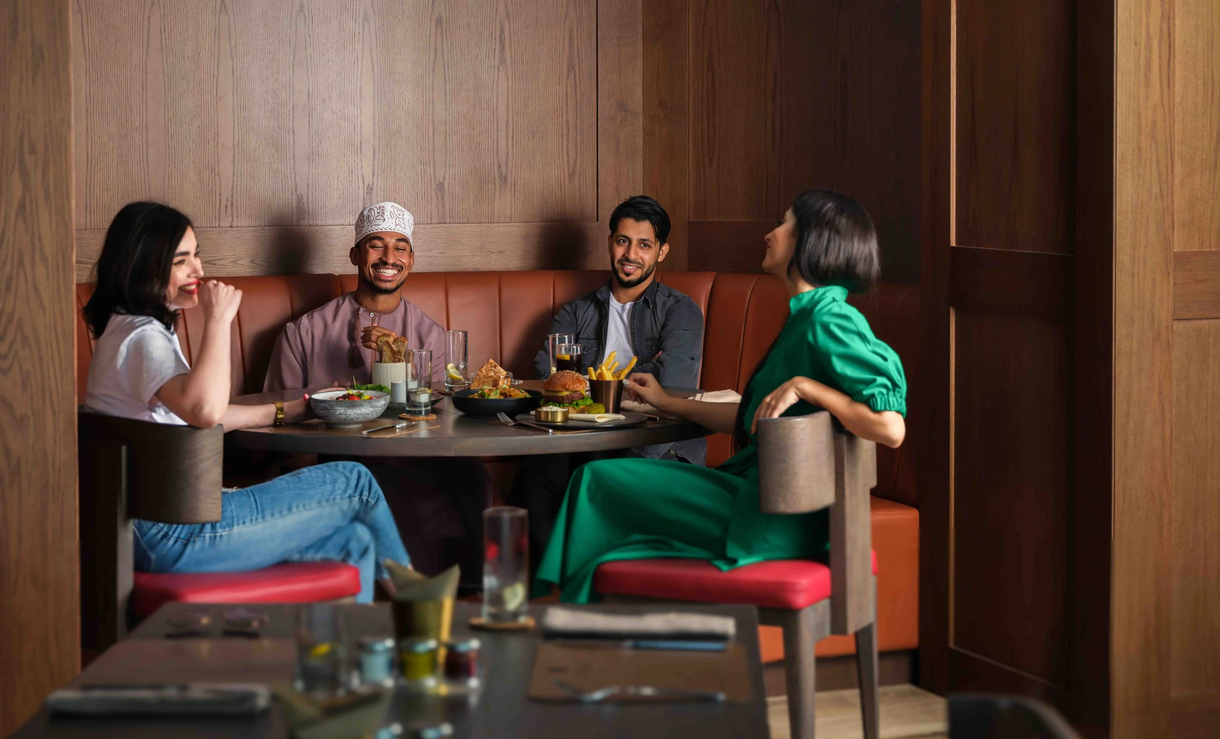 4 friends enjoying dinner in booth in sport bar
