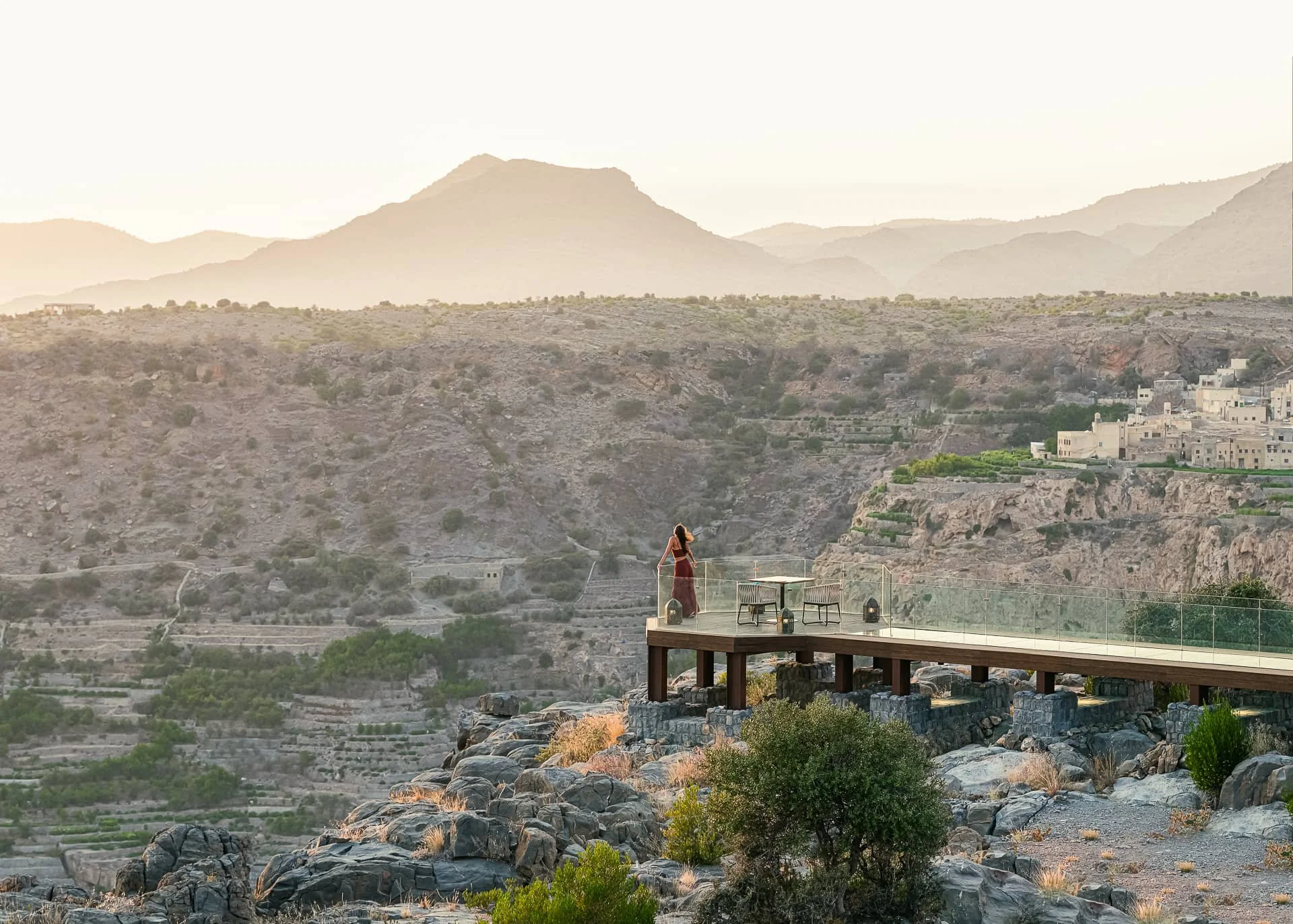 Anantara Al Jabal Akhdar - Lady admires view and looking to cliff during sunset in Diana's point