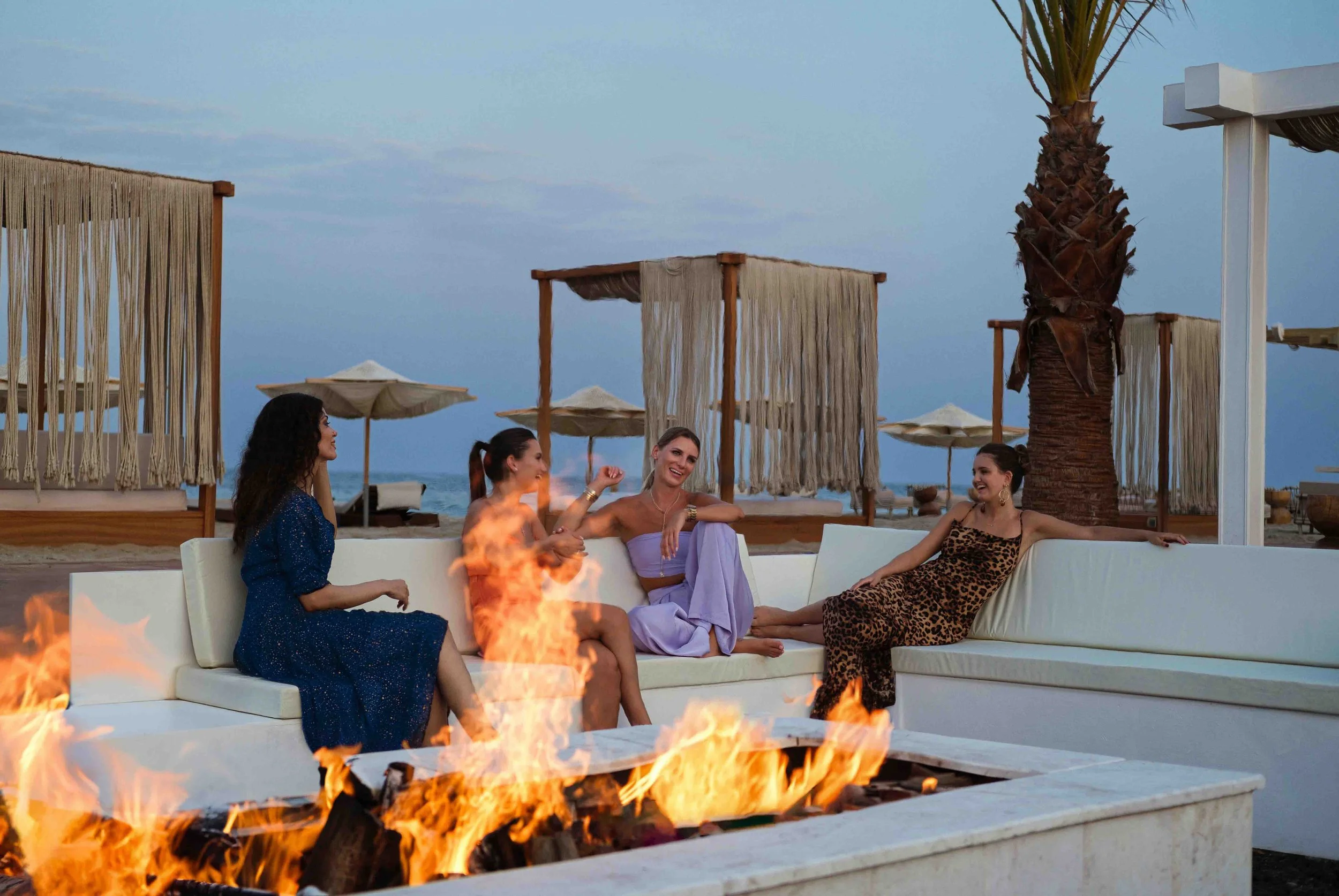 four ladies enjoying fire after sunset