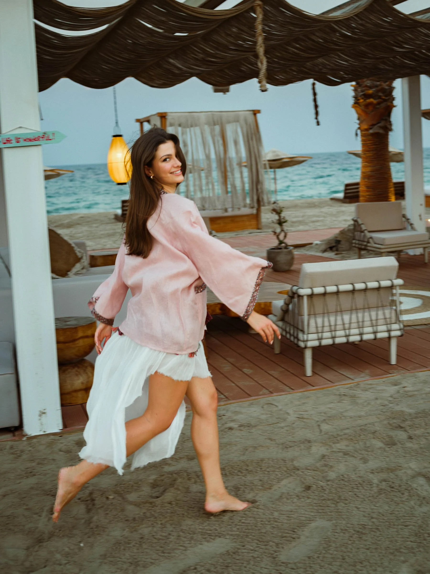 women running on the beach side cabana
