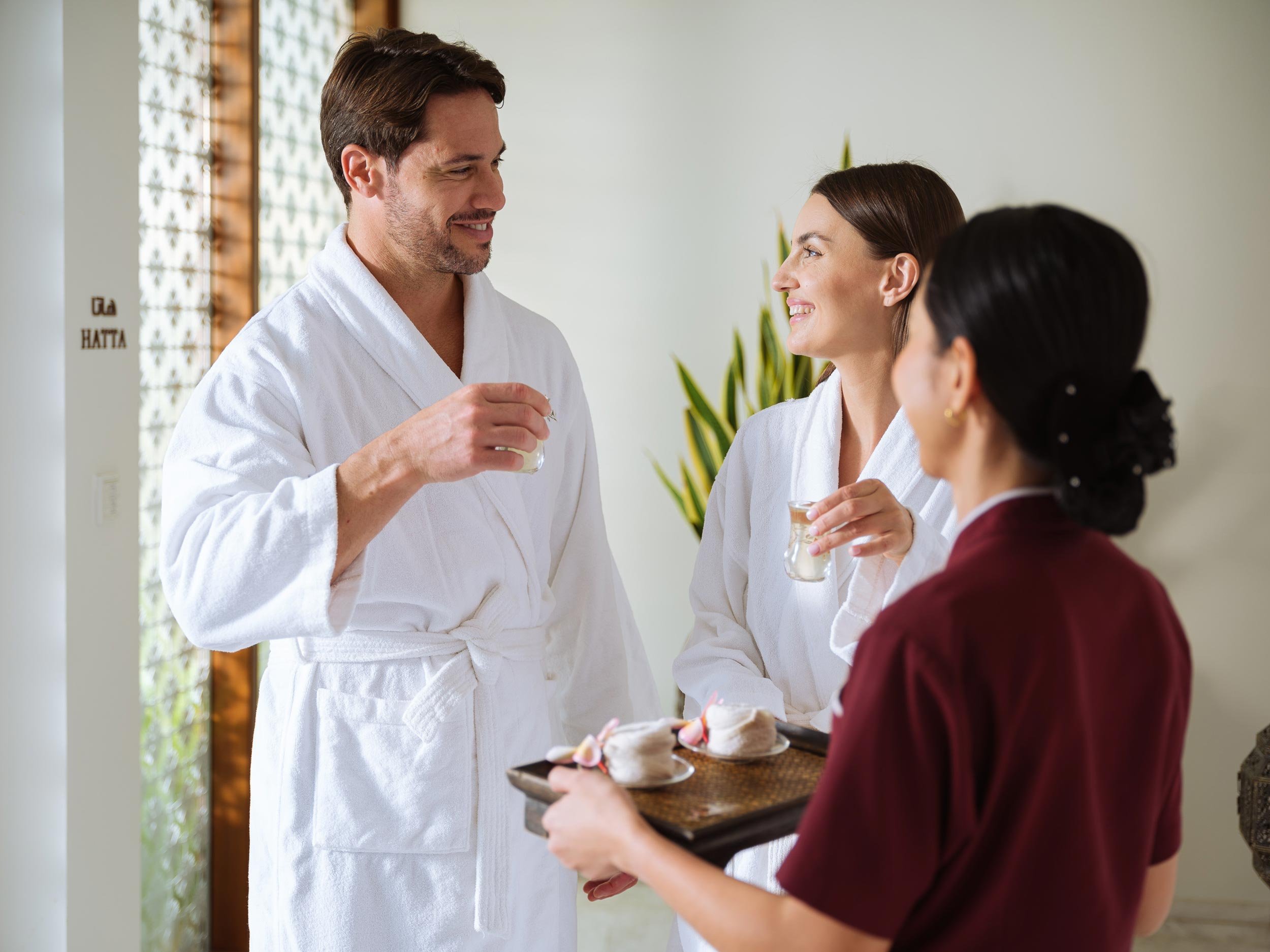 Spa staff members in robes sharing drinks and snacks