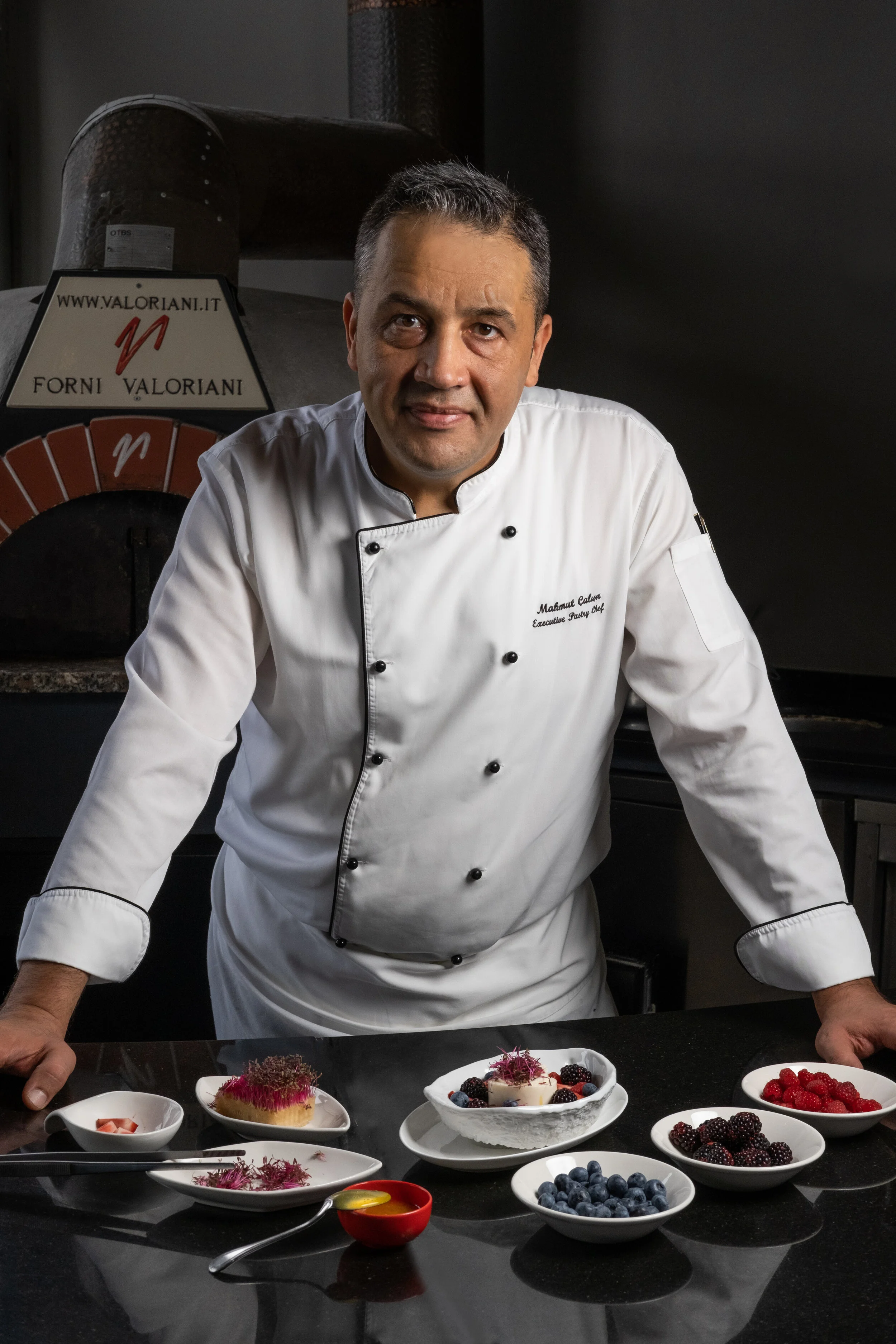 Pastry Chef Posing in front of dessert