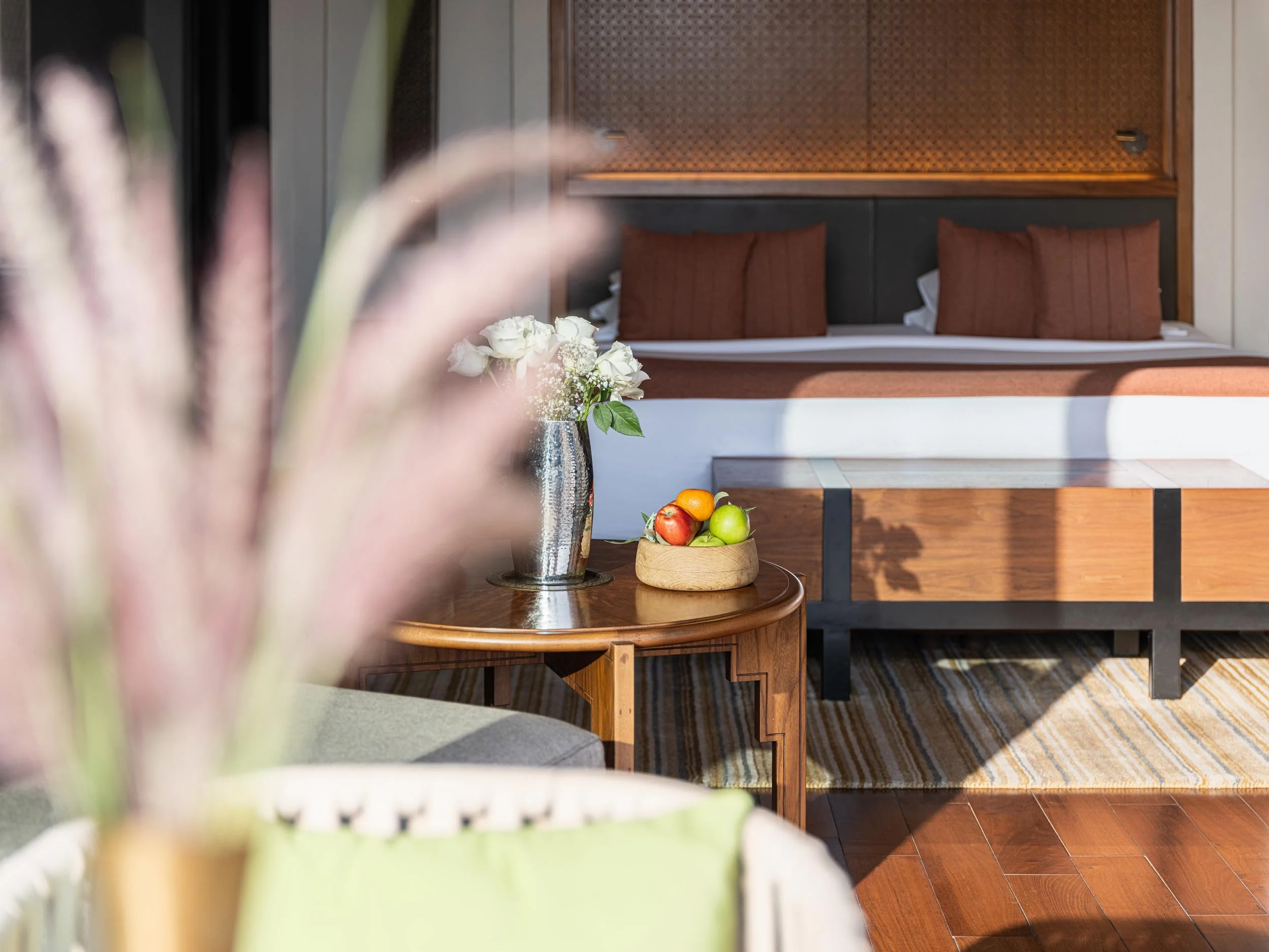 Anantara Al Jabal Akhdar - Deluxe room with plant in foreground and sun beam on the bed