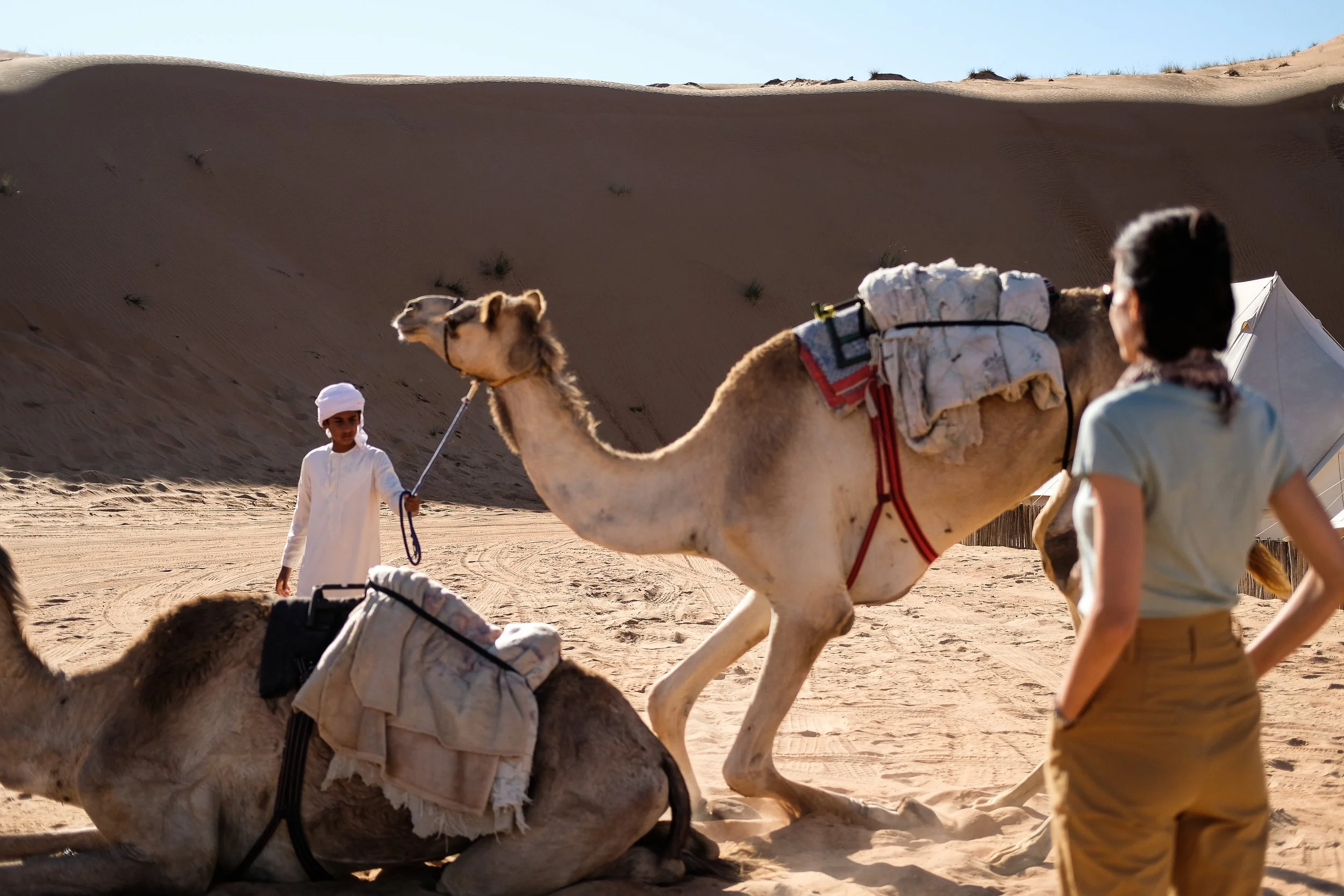lady preparing to take a ride on camel in desert camp