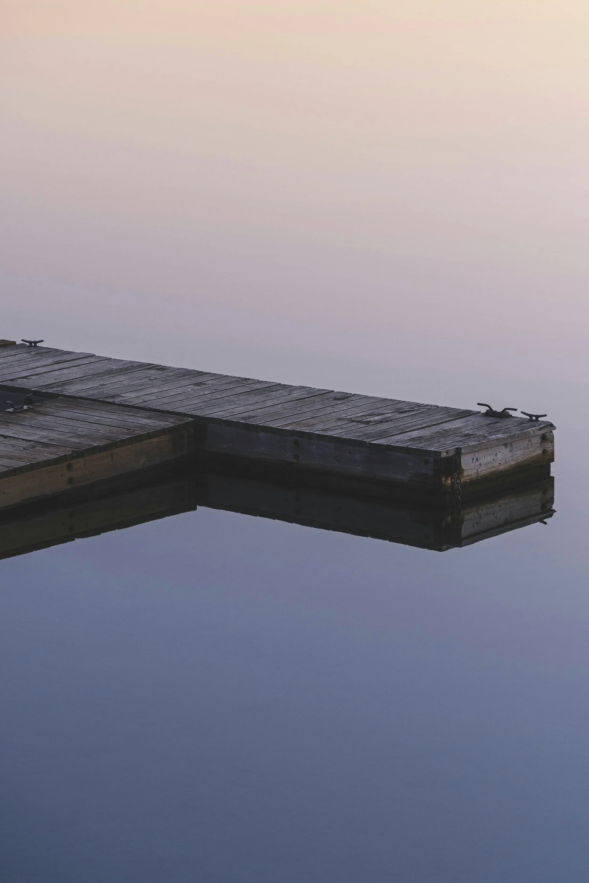 Wooden dock over calm water symbolizing slowing down and nervous system regulation