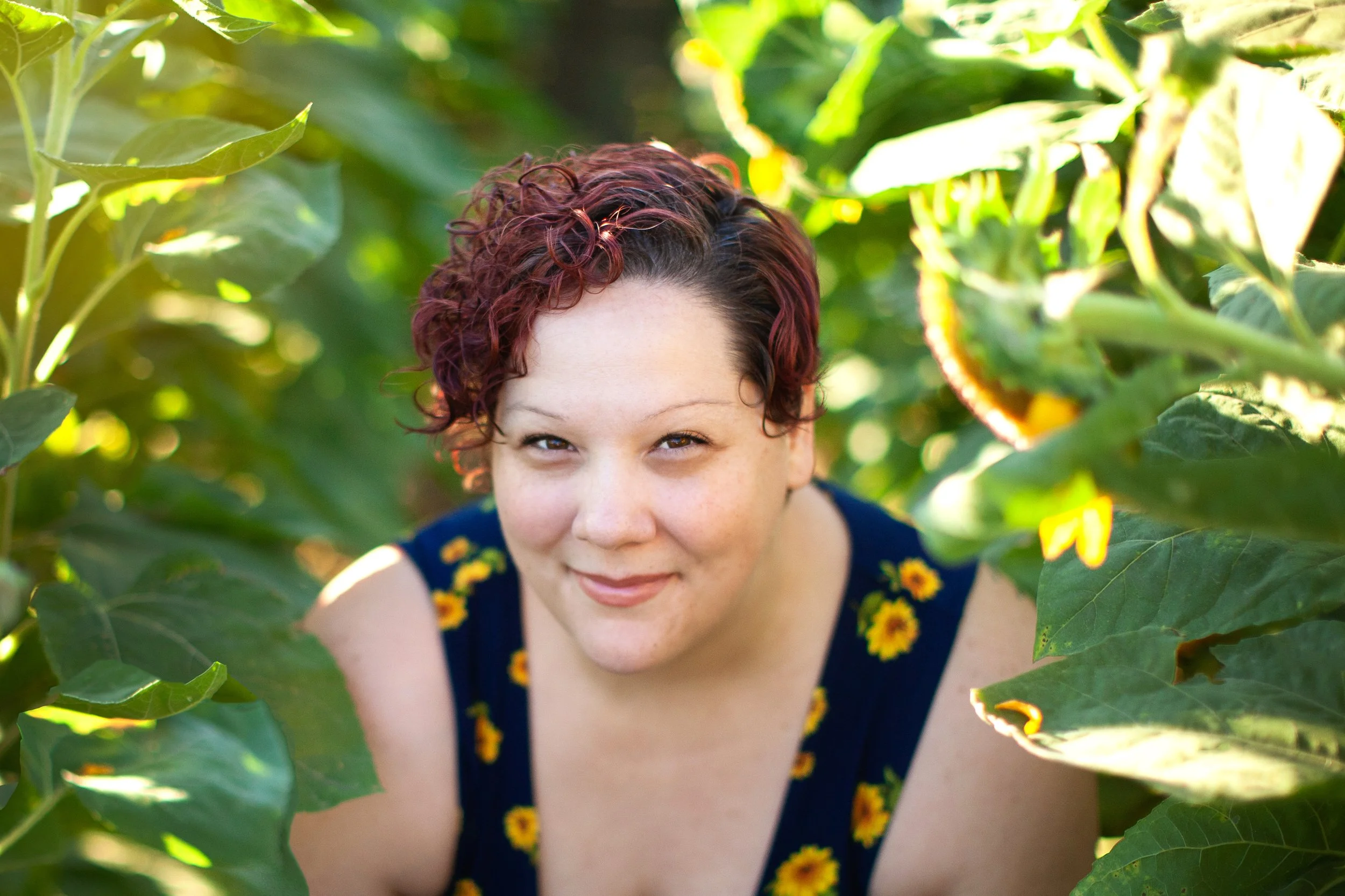 Kandace Ledergerber, EMDR therapist in Phoenix, smiling outdoors among sunflowers.