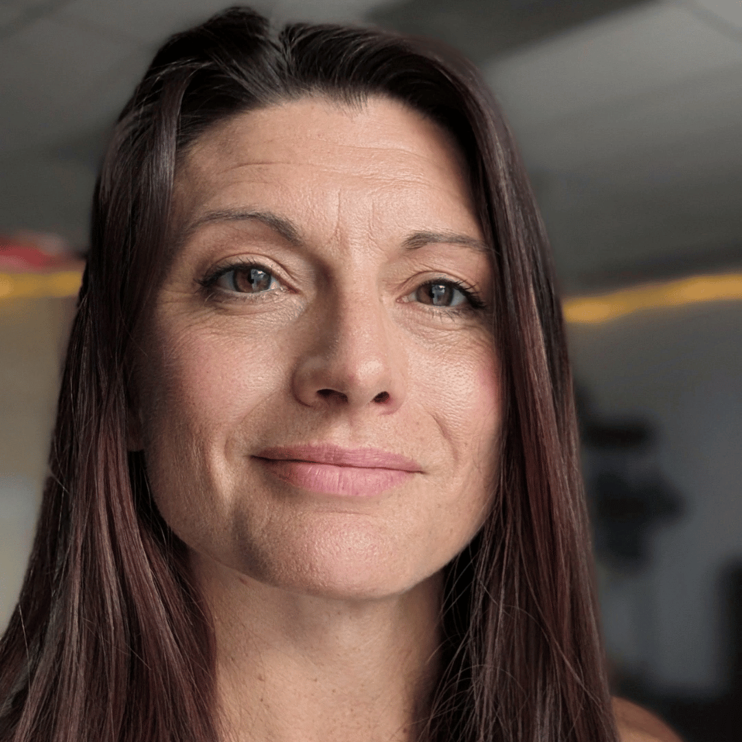 Headshot of Katie Wilson, Phoenix movement coach, with long dark auburn hair and a warm, closed-lip smile