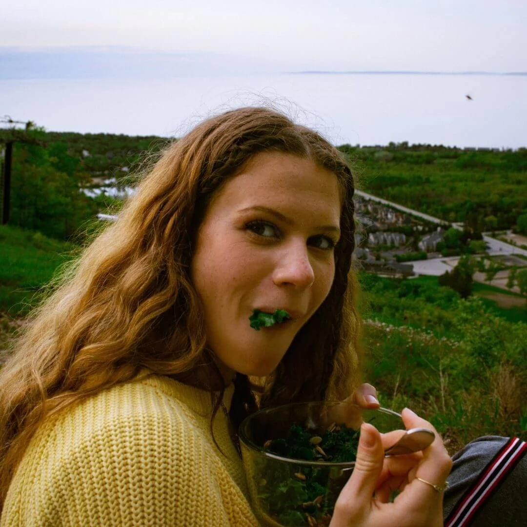 Young adult practicing mindful eating while eating a kale salad at the Blue Mountains.