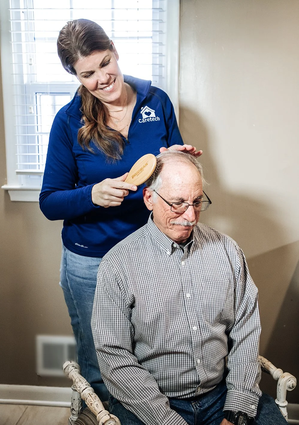 Caretech caregiver providing personal care to a senior by helping with hygiene. 