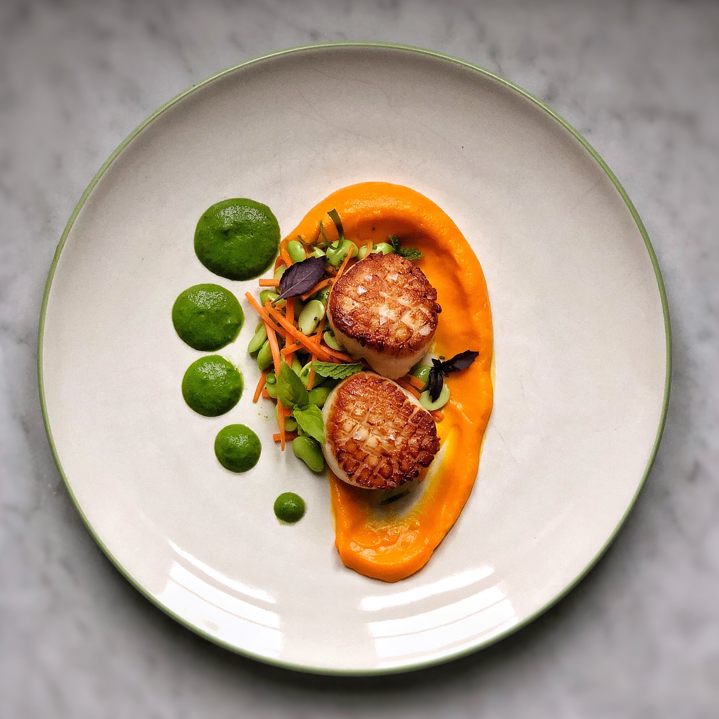 Seared diver scallops over a carrot and coconut puree with edamame and a fresh green curry sauce