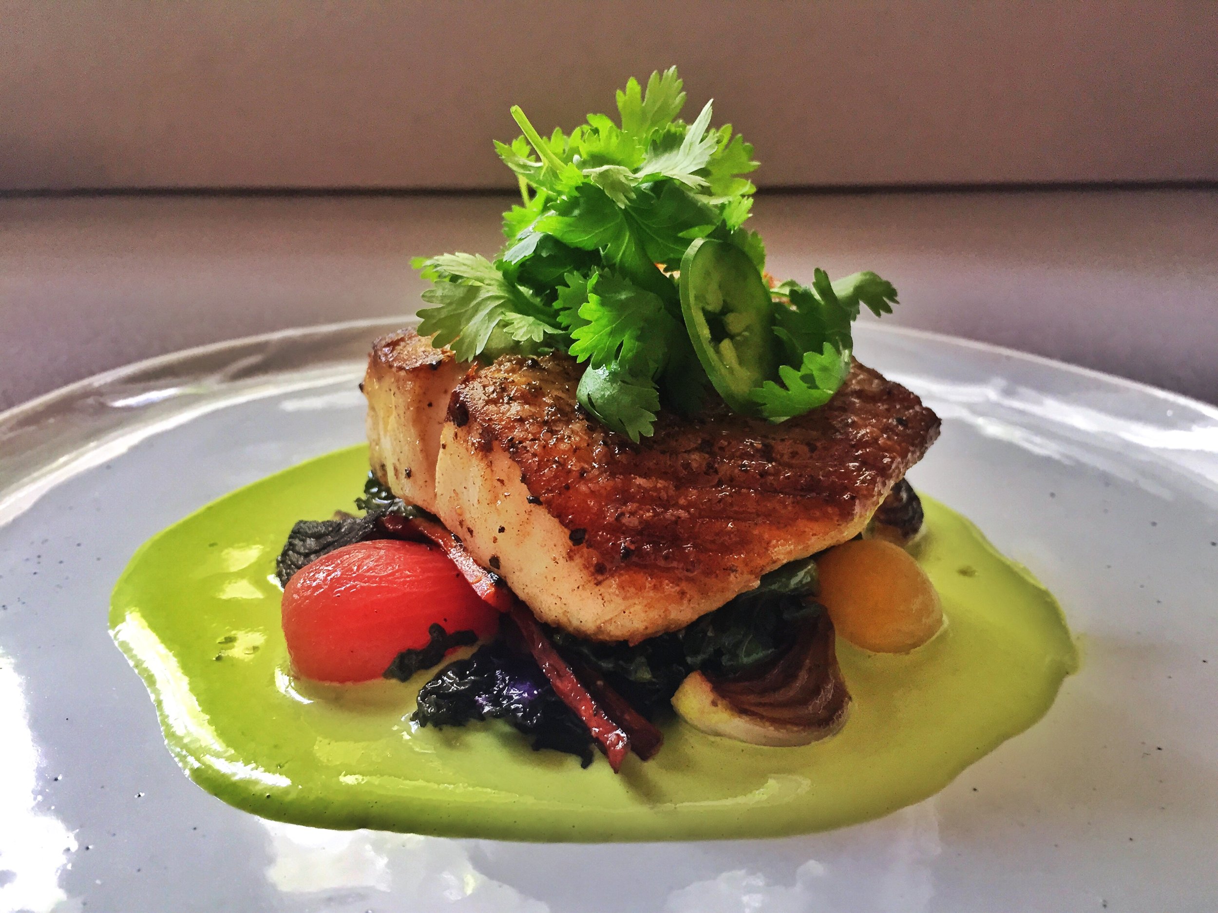 Pan roasted black grouper over charred vegetables with a cilantro salsa verde