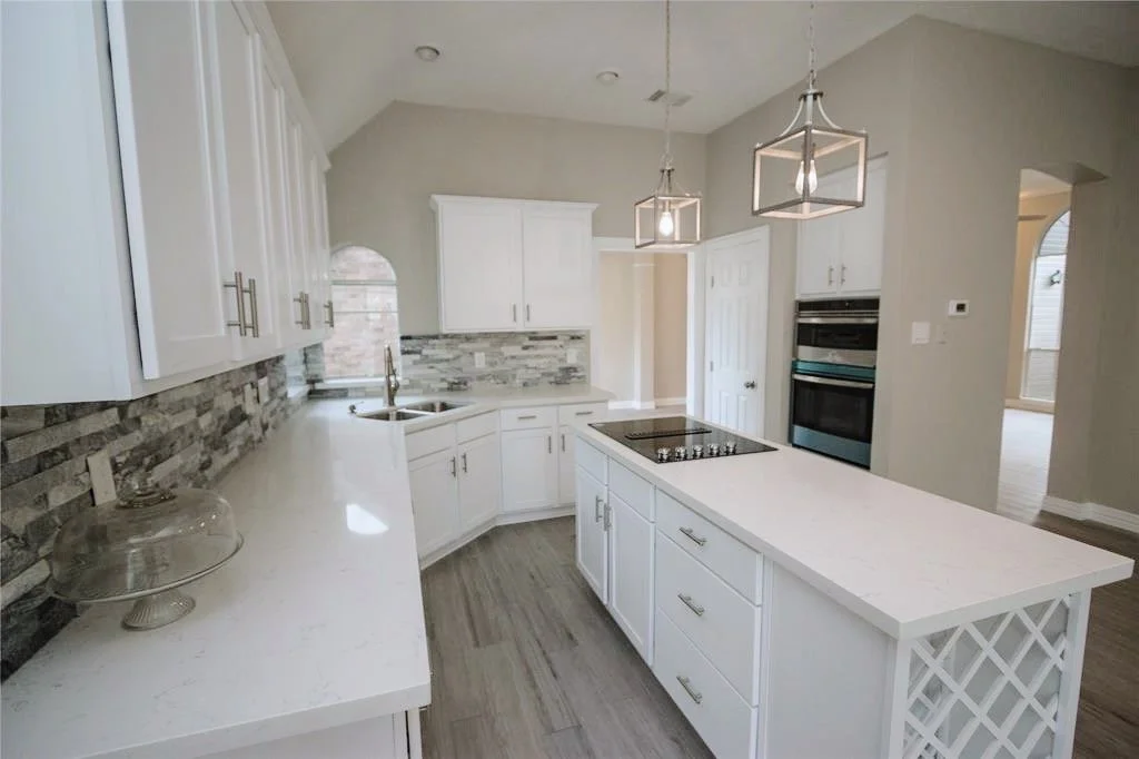 Wine rack, stove-top island kitchen with a double oven combination.