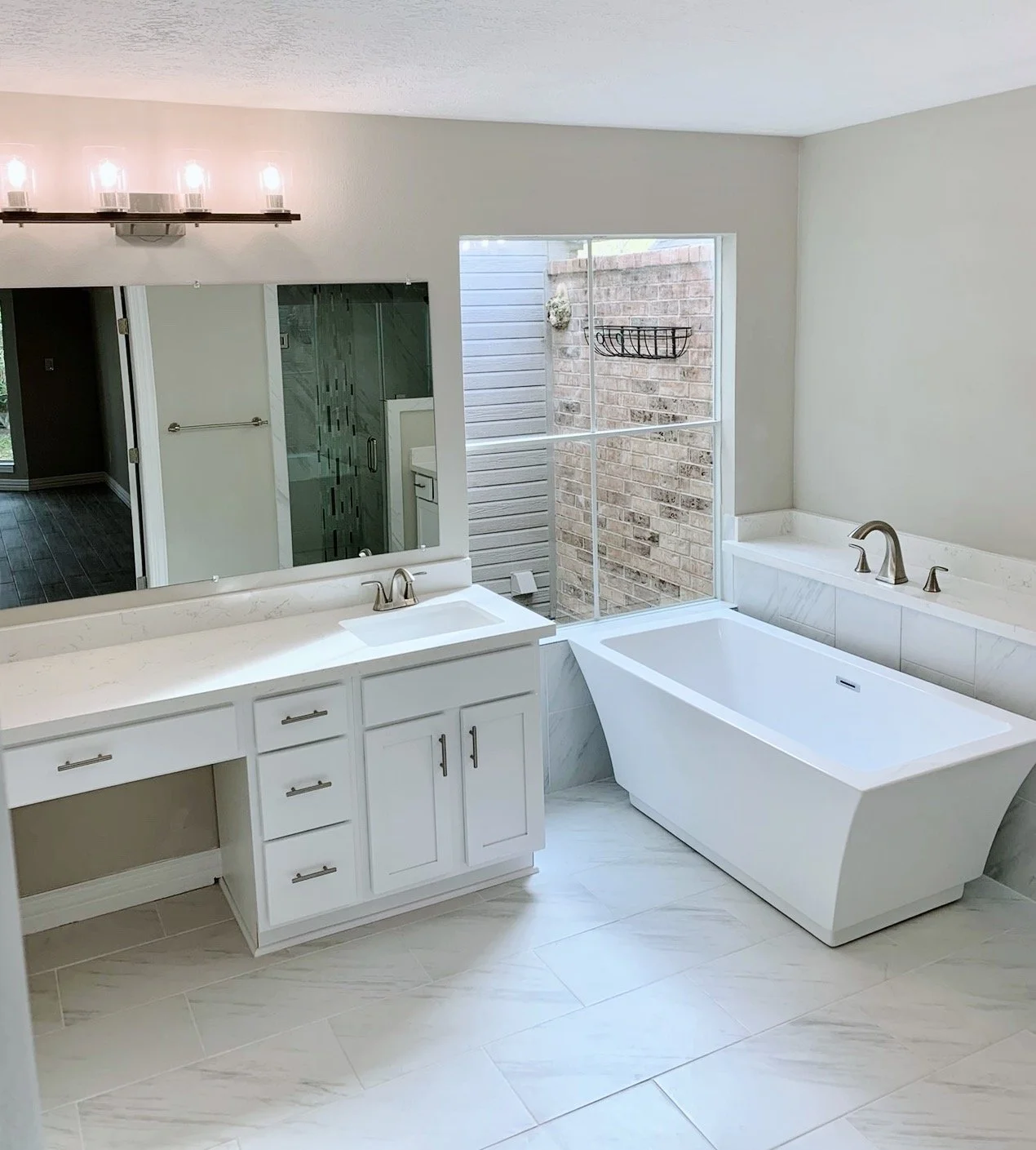 Primary bathroom with a double vanity and freestanding bathtub.