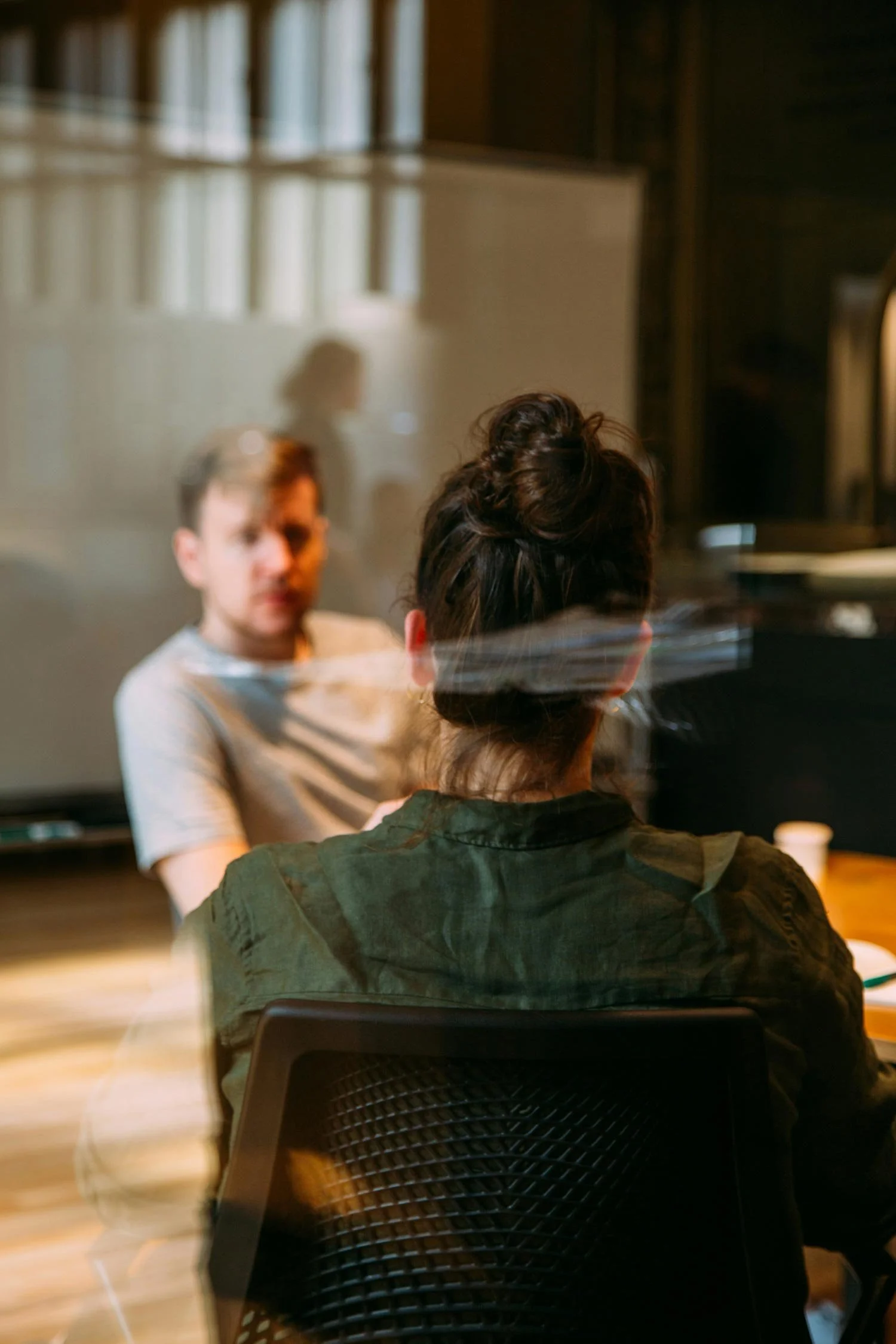 People sitting at a table in a room with warm lighting and a blurred background.