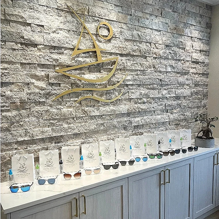 High quality polarized sunglasses lined up in a row on a countertop beneath the Lakeshore Optometry logo